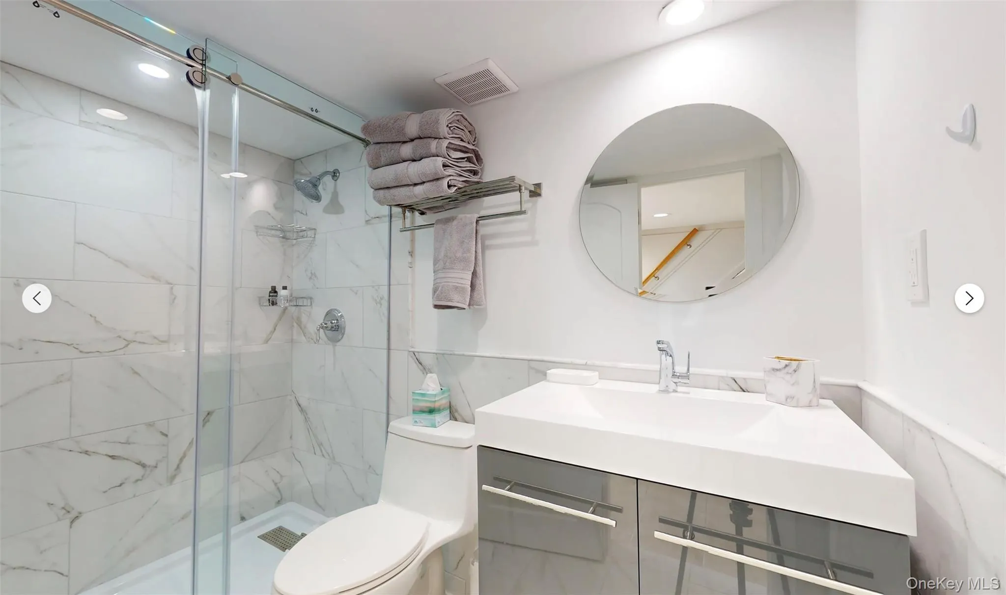 Bathroom featuring an enclosed shower, vanity, and toilet Bathroom featuring an enclosed shower, vanity, and toilet
