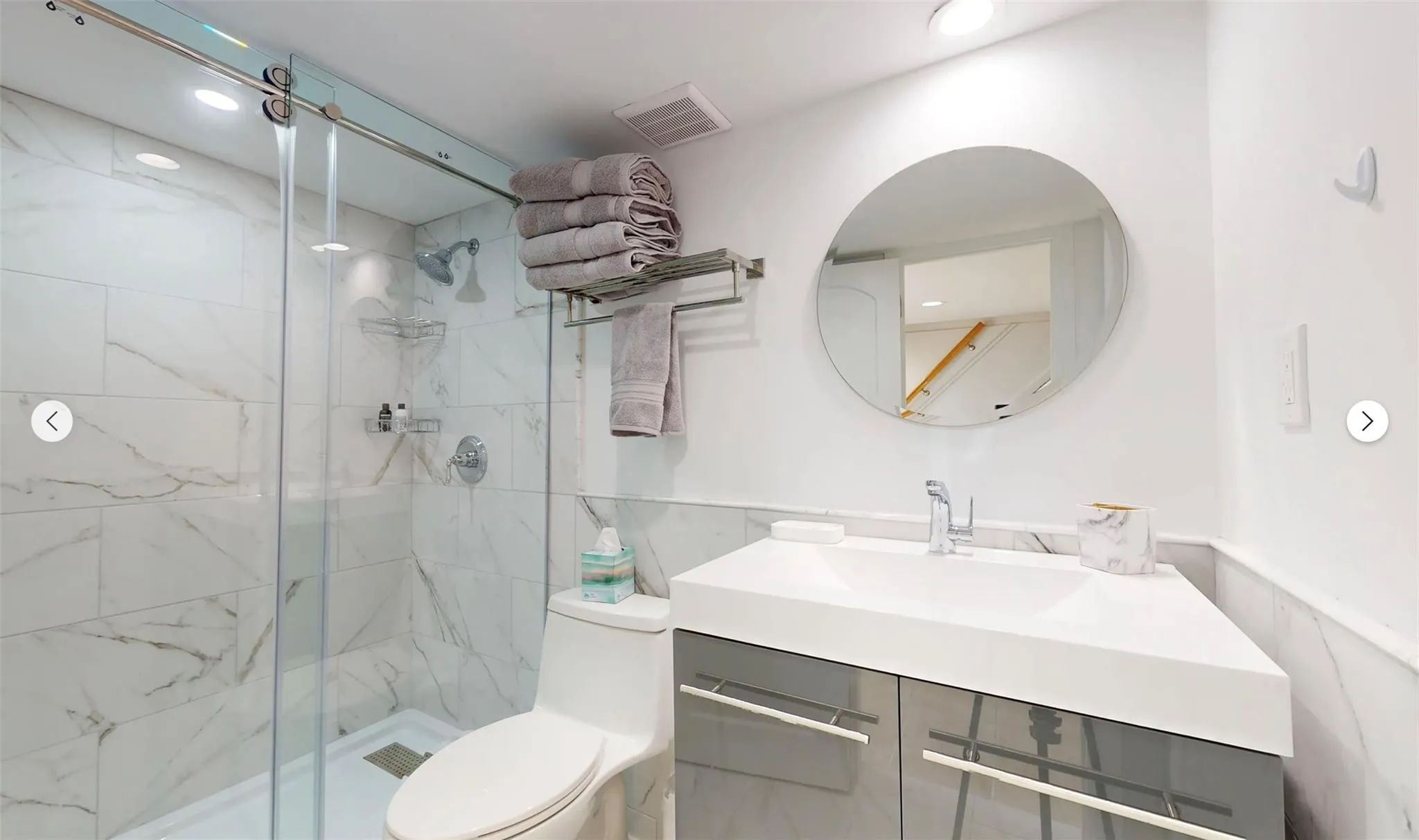 Bathroom featuring an enclosed shower, vanity, and toilet Bathroom featuring an enclosed shower, vanity, and toilet