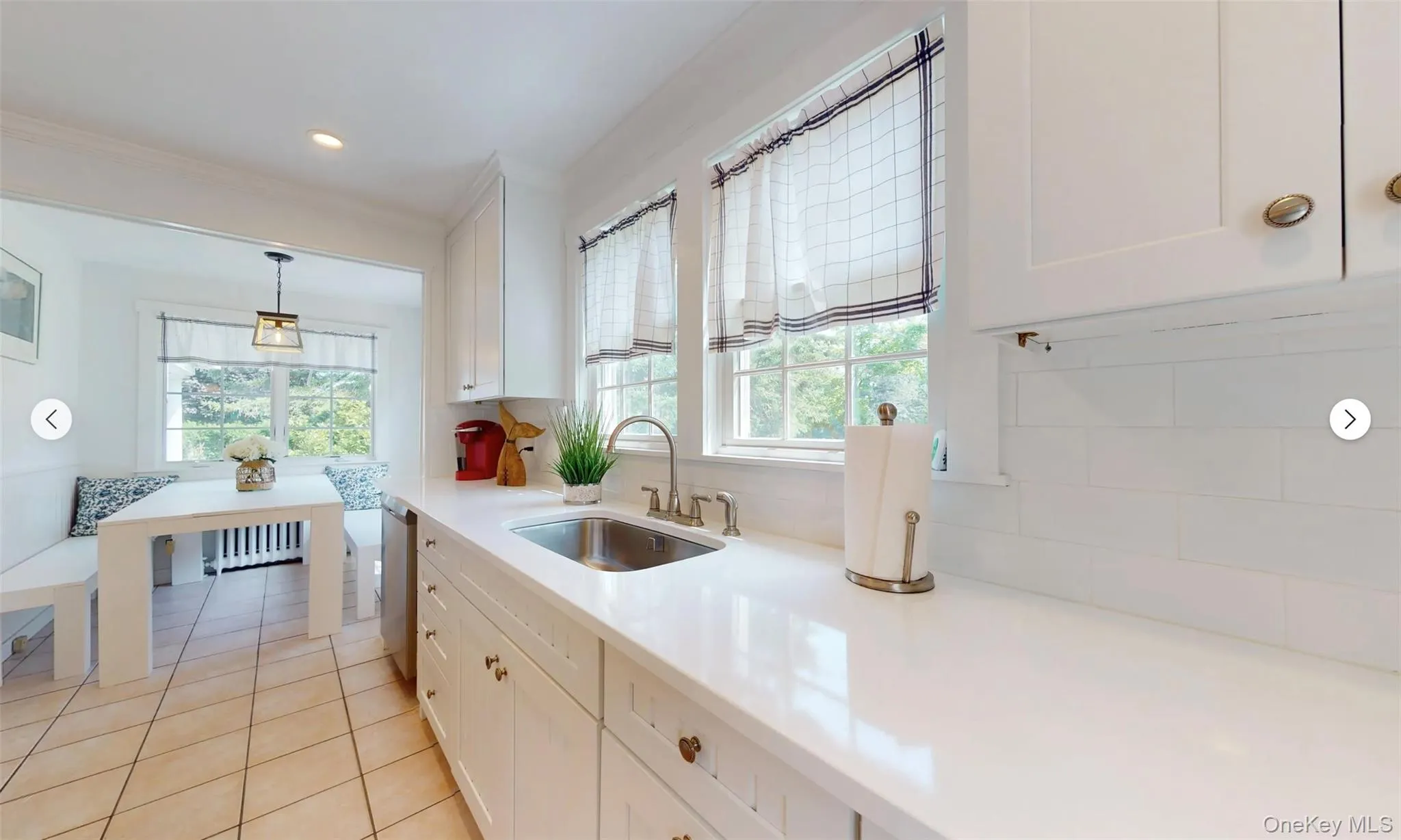 Kitchen with dishwasher, sink, white cabinets, and decorative light fixtures Kitchen with dishwasher, sink, white cabinets, and decorative light fixtures