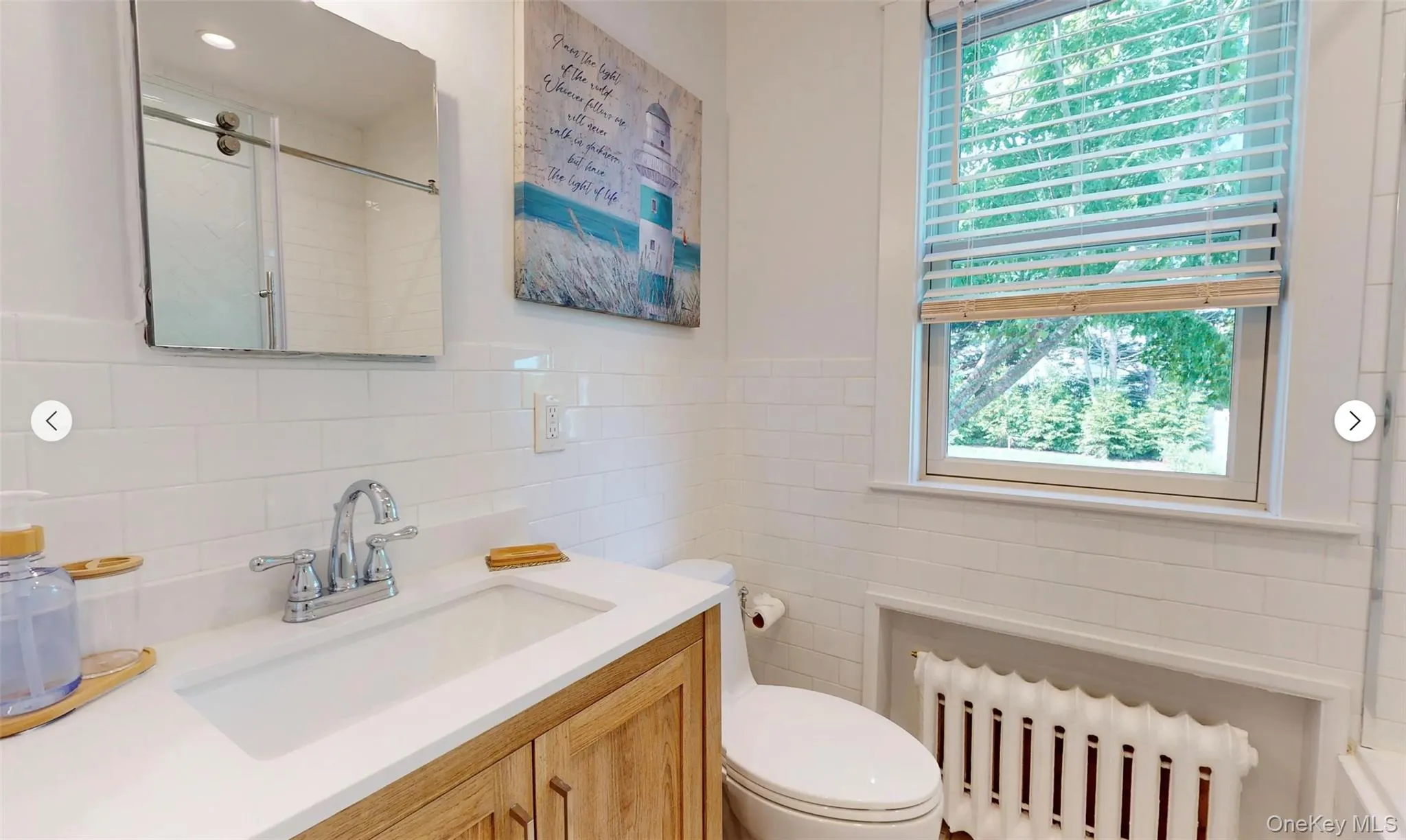 Bathroom featuring radiator, tile walls, vanity, walk in shower, and toilet Bathroom featuring radiator, tile walls, vanity, walk in shower, and toilet