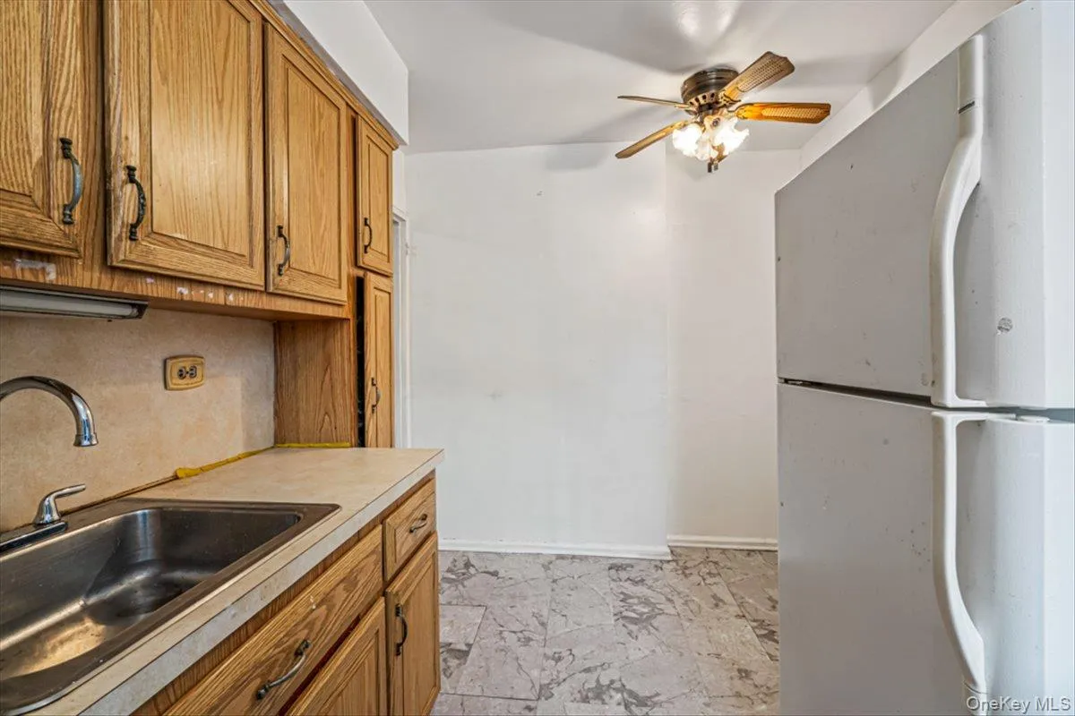 Kitchen featuring sink, ceiling fan, and white refrigerator Kitchen featuring sink, ceiling fan, and white refrigerator