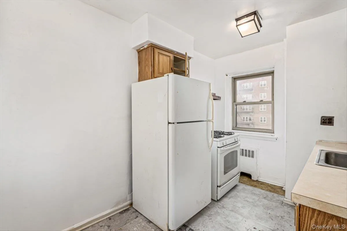 Kitchen featuring white appliances and radiator heating unit Kitchen featuring white appliances and radiator heating unit