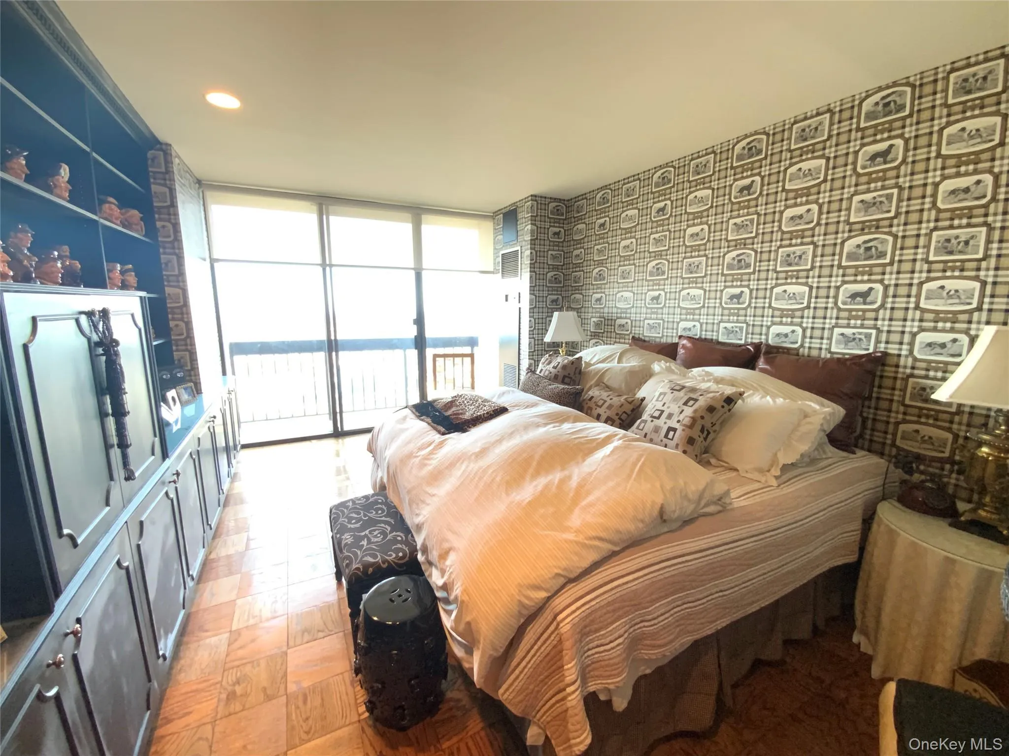 Bedroom with a wall of windows, access to outside, a water view, wallpapered walls, and recessed lighting Bedroom with a wall of windows, access to outside, a water view, wallpapered walls, and recessed lighting