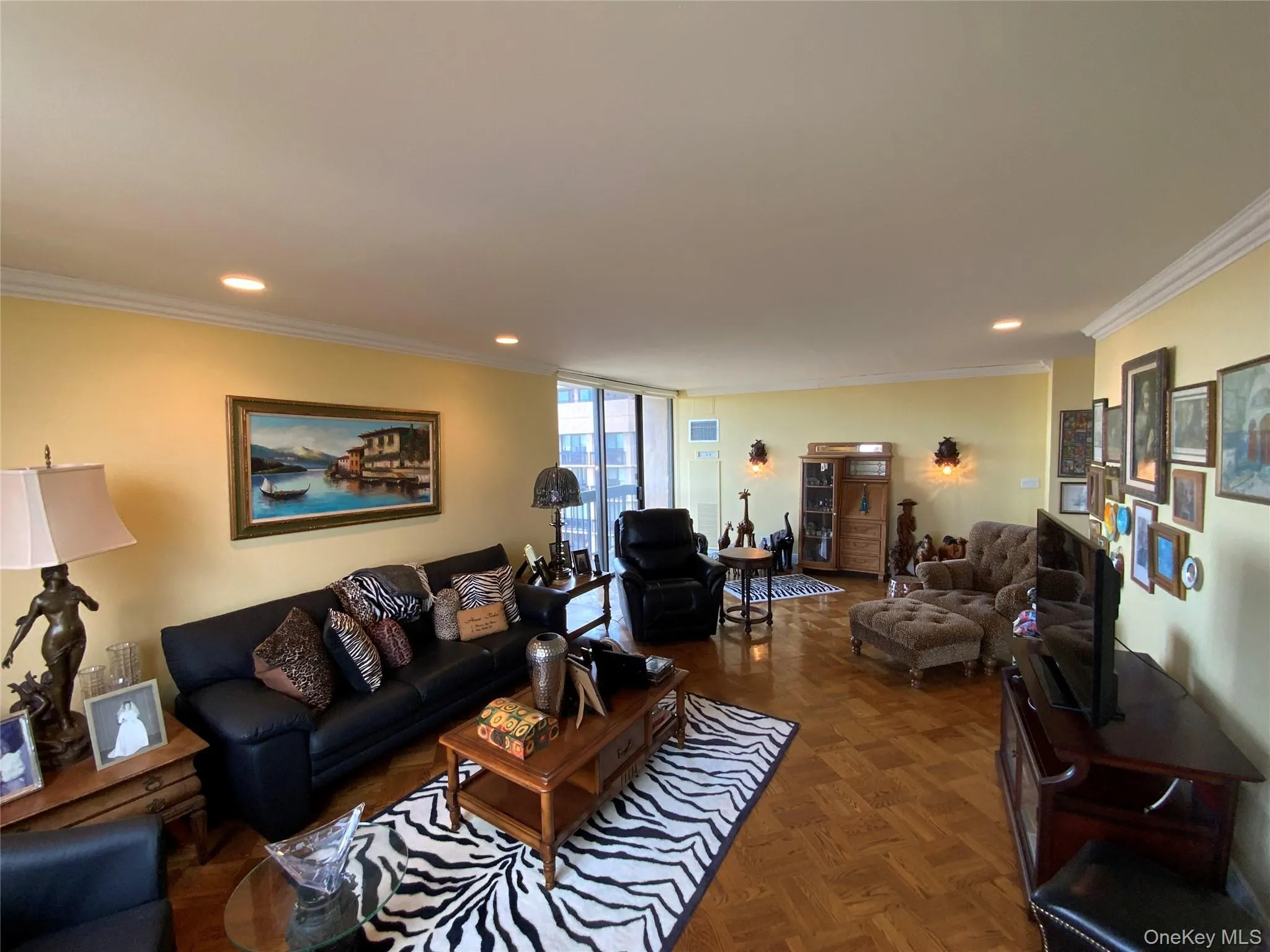 Living area featuring ornamental molding, recessed lighting, and expansive windows Living area featuring ornamental molding, recessed lighting, and expansive windows