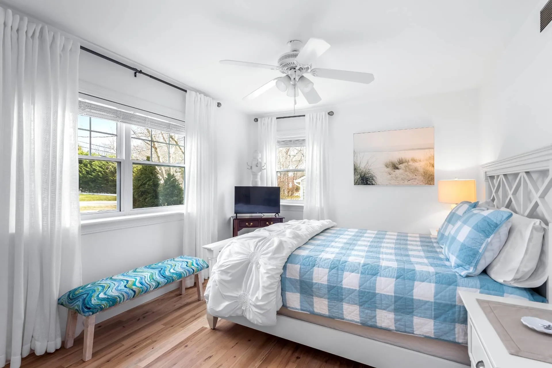 Bedroom featuring multiple windows, hardwood / wood-style floors, and ceiling fan Bedroom featuring multiple windows, hardwood / wood-style floors, and ceiling fan