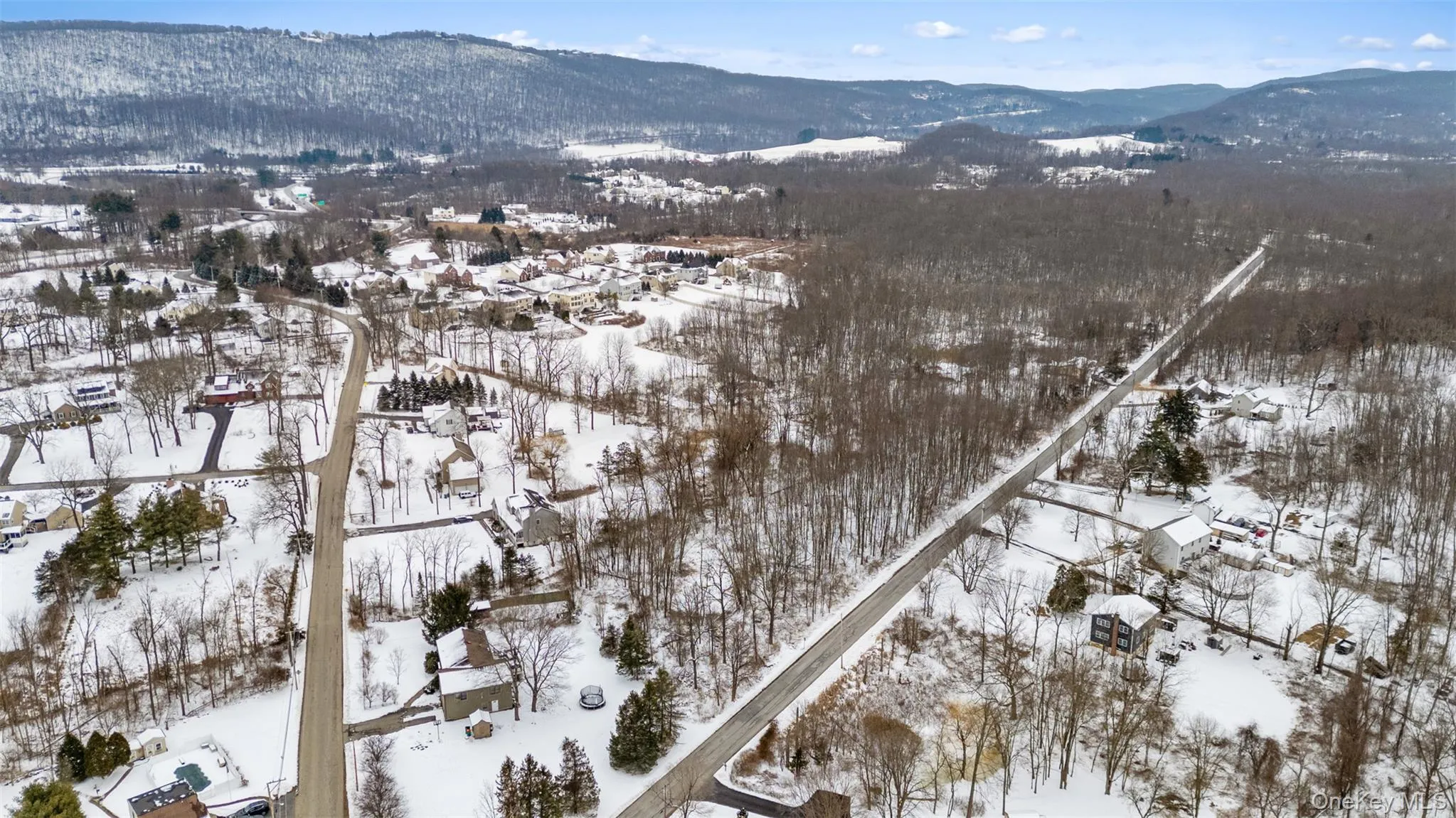 Snowy aerial view featuring a mountain view Snowy aerial view featuring a mountain view