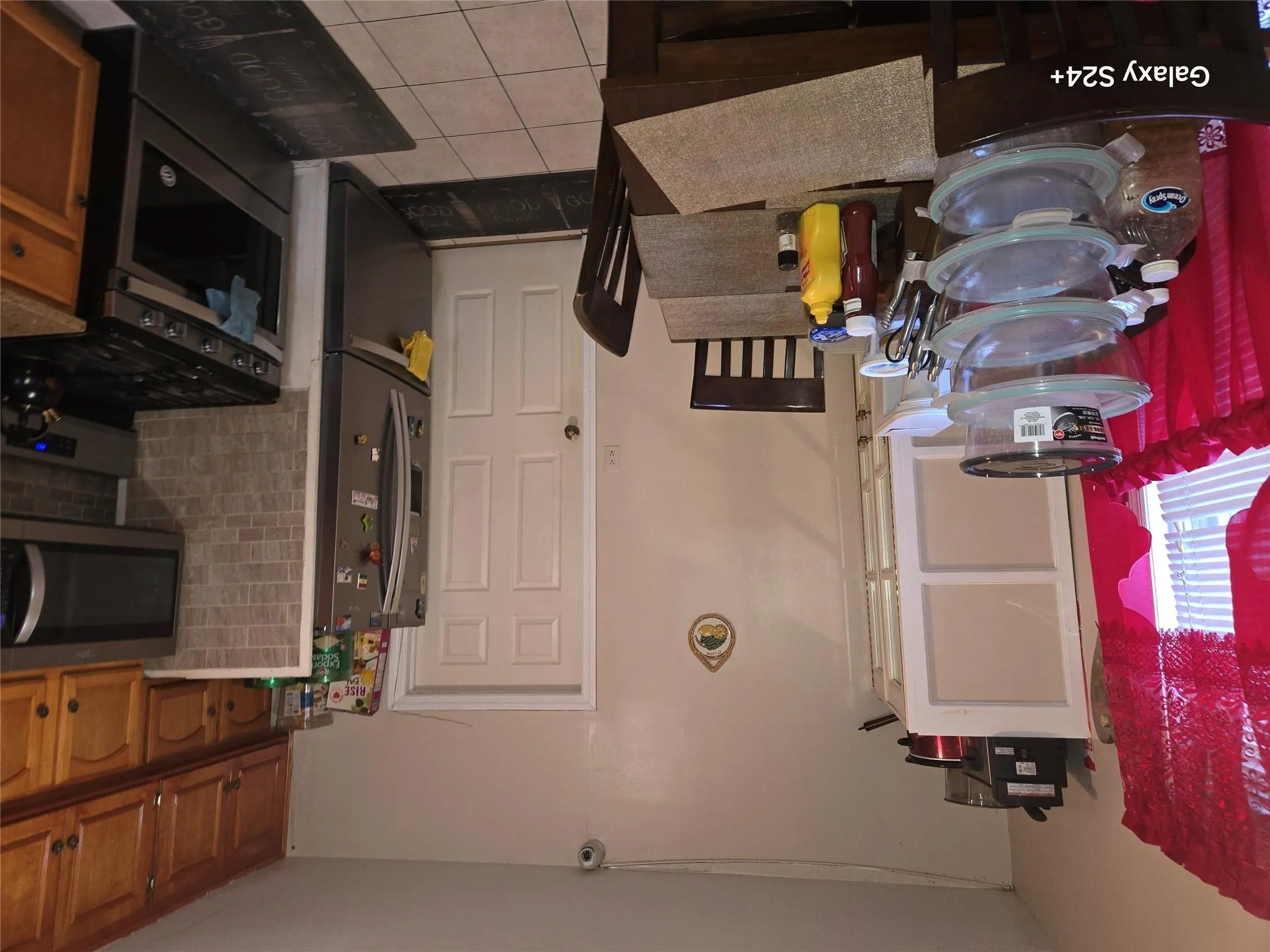 Kitchen featuring fridge, backsplash, range, and light tile patterned floors Kitchen featuring fridge, backsplash, range, and light tile patterned floors