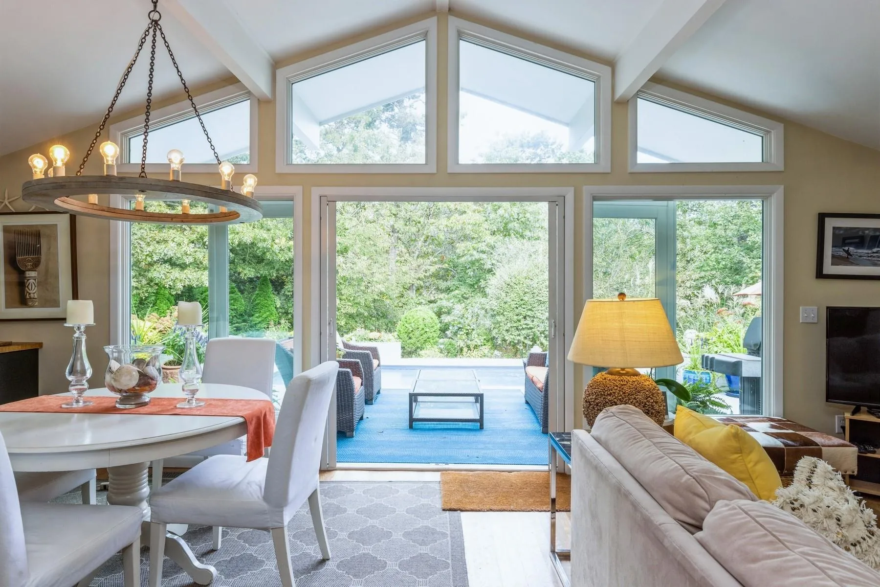 Dining space with an inviting chandelier, vaulted ceiling with beams, and light wood-type flooring Dining space with an inviting chandelier, vaulted ceiling with beams, and light wood-type flooring