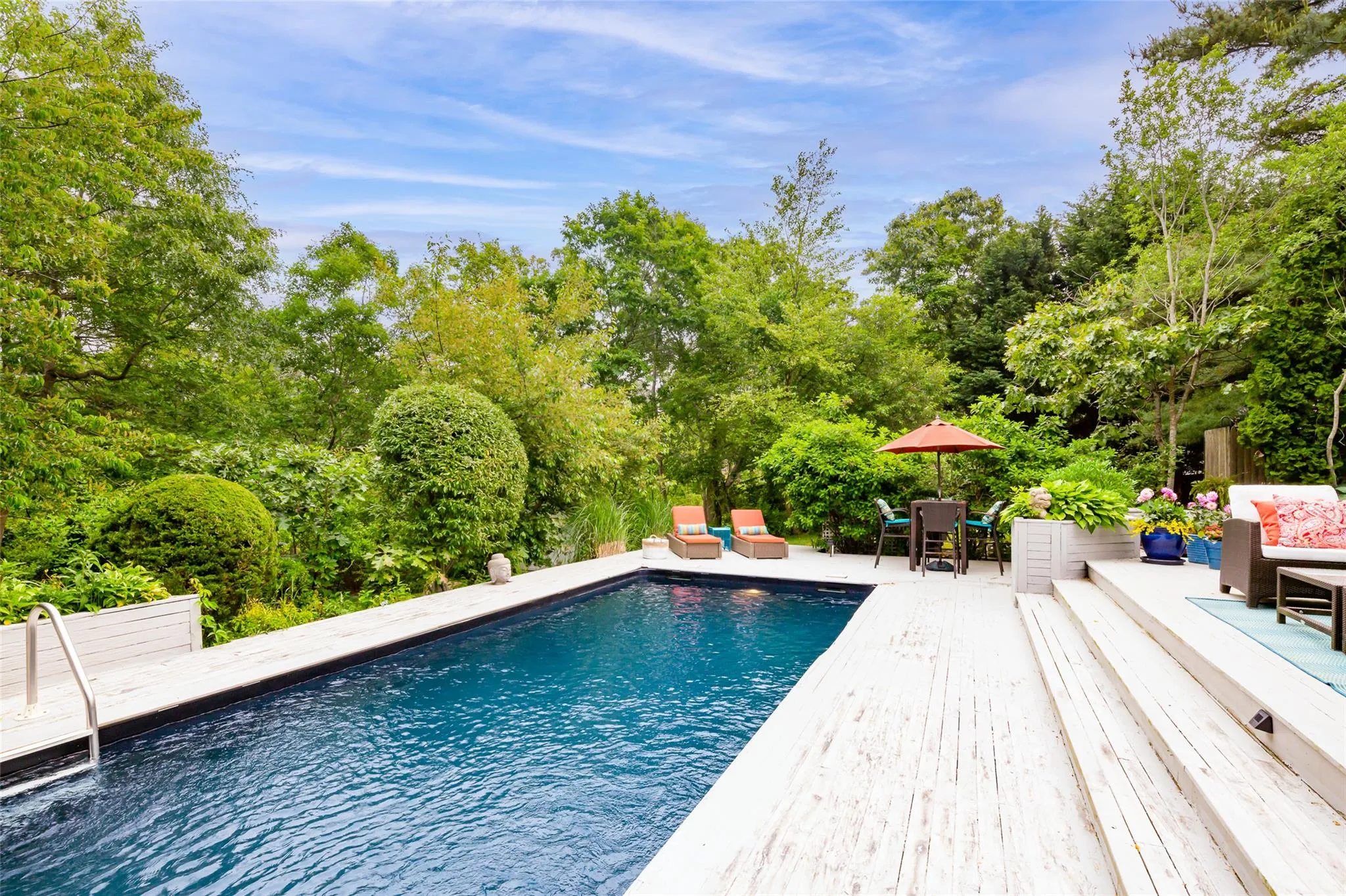 Pool with a wooden deck, outdoor lounge area, and a patio Pool with a wooden deck, outdoor lounge area, and a patio
