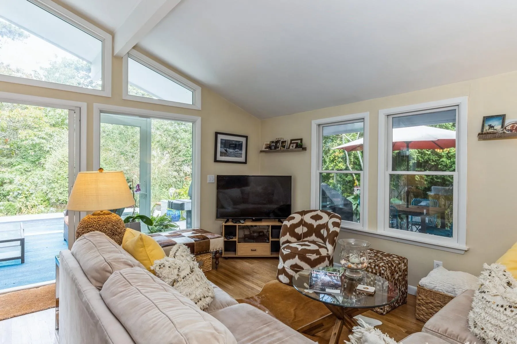 Living room featuring lofted ceiling with beams and light hardwood / wood-style floors Living room featuring lofted ceiling with beams and light hardwood / wood-style floors