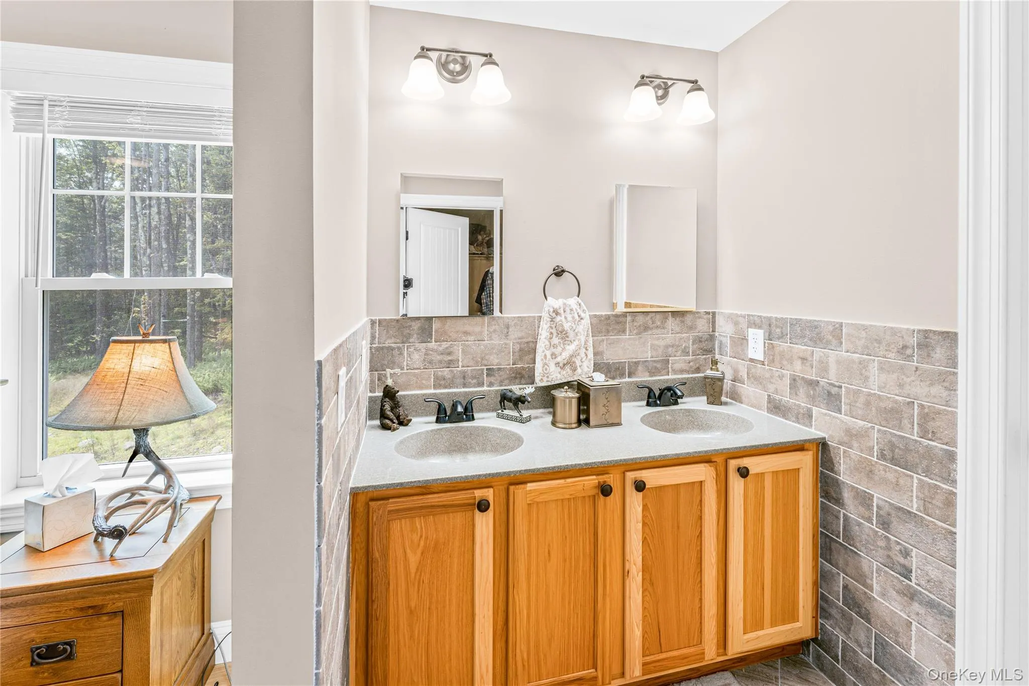 Bathroom featuring double vanity and tile walls Bathroom featuring double vanity and tile walls