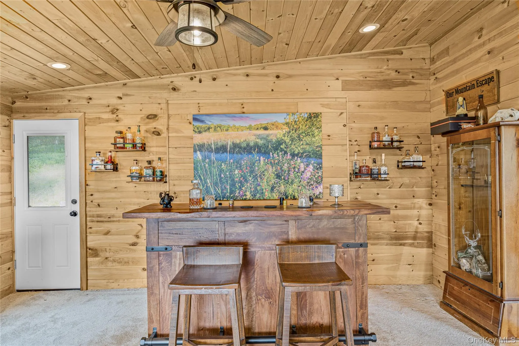 Indoor bar with wood walls, vaulted ceiling, carpet, wood ceiling, and recessed lighting Indoor bar with wood walls, vaulted ceiling, carpet, wood ceiling, and recessed lighting