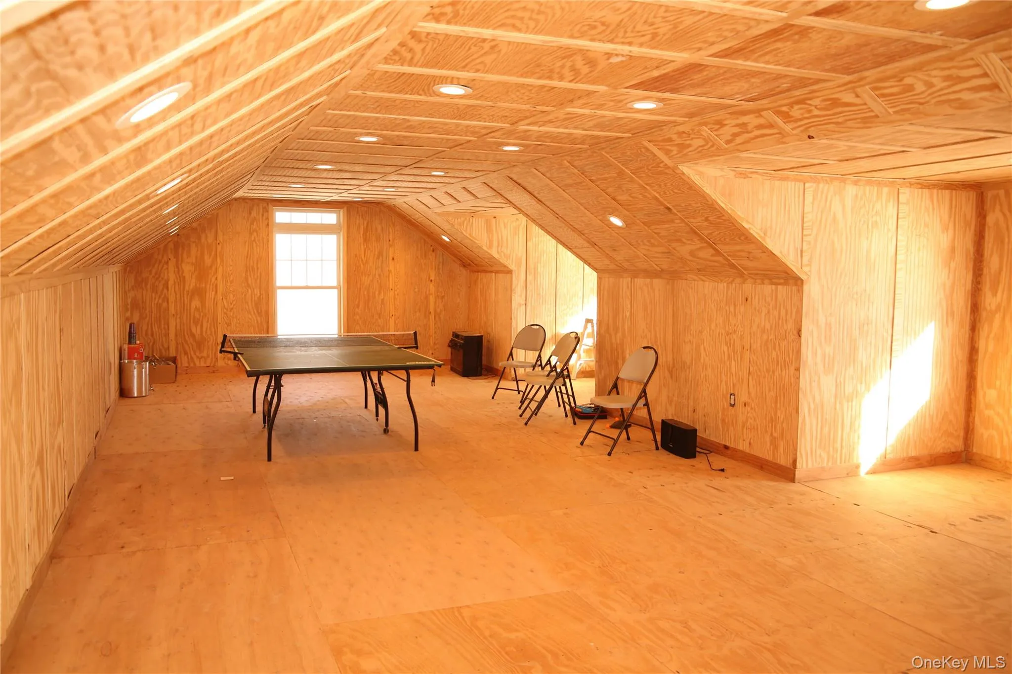 Bunkhouse attic featuring lofted ceiling and wooden walls Bunkhouse attic featuring lofted ceiling and wooden walls