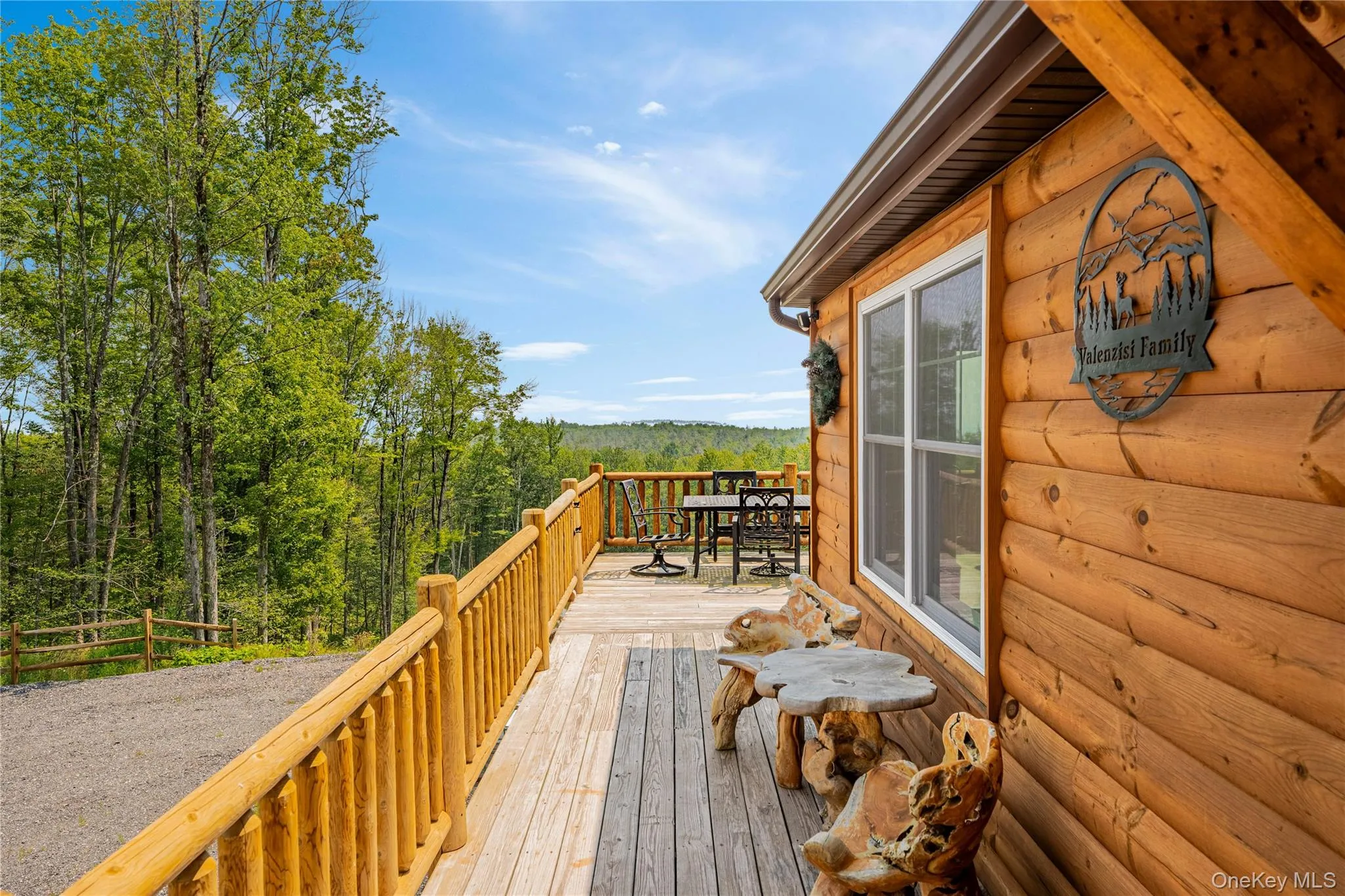 Wooden terrace featuring a view of trees and outdoor dining space Wooden terrace featuring a view of trees and outdoor dining space