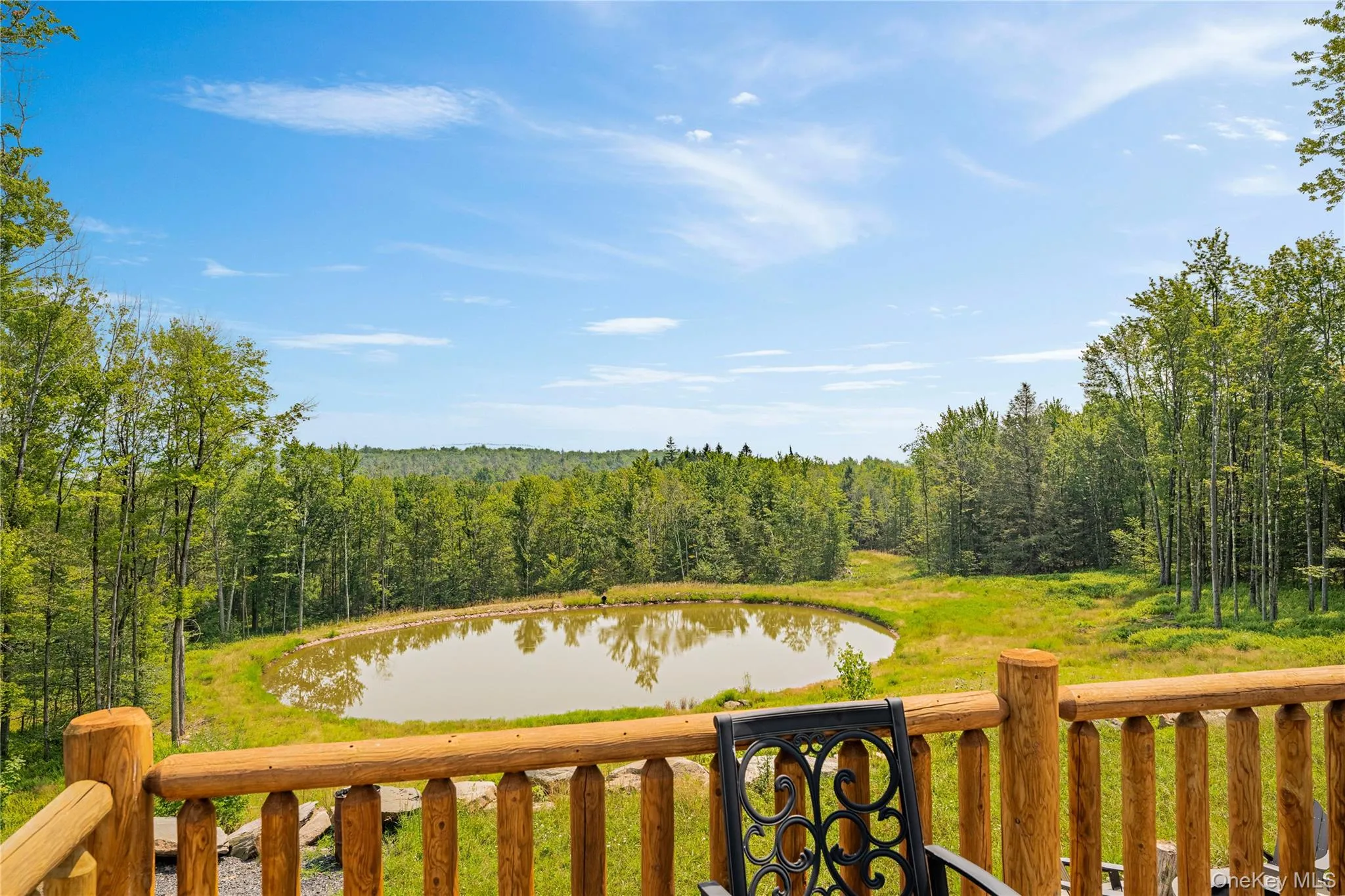 Wooden terrace featuring a water view and a view of trees Wooden terrace featuring a water view and a view of trees