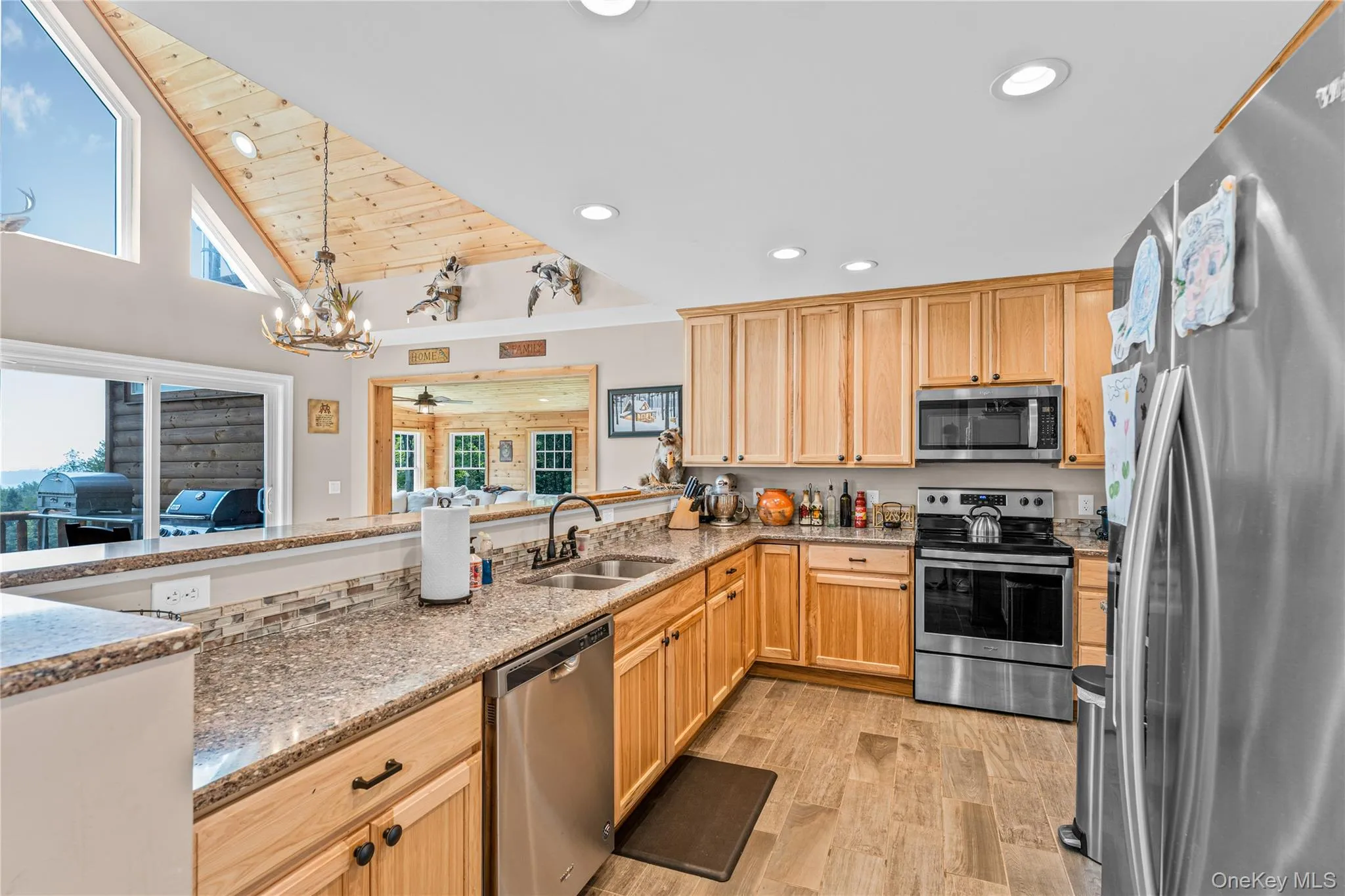 Kitchen with stainless steel appliances, a chandelier, light wood-style flooring, recessed lighting, and plenty of natural light Kitchen with stainless steel appliances, a chandelier, light wood-style flooring, recessed lighting, and plenty of natural light