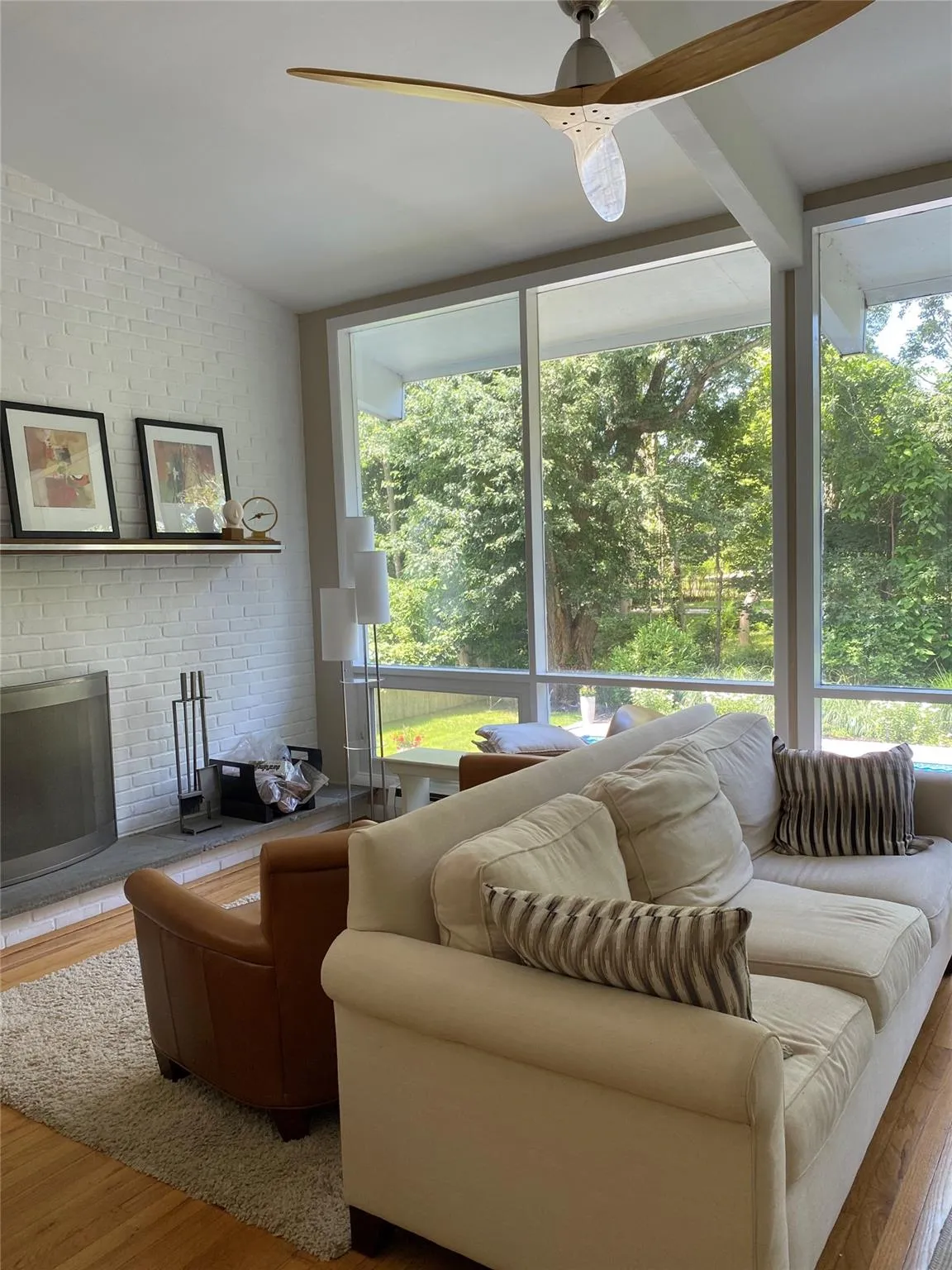 Living room with hardwood / wood-style flooring, vaulted ceiling, plenty of natural light, and a fireplace Living room with hardwood / wood-style flooring, vaulted ceiling, plenty of natural light, and a fireplace
