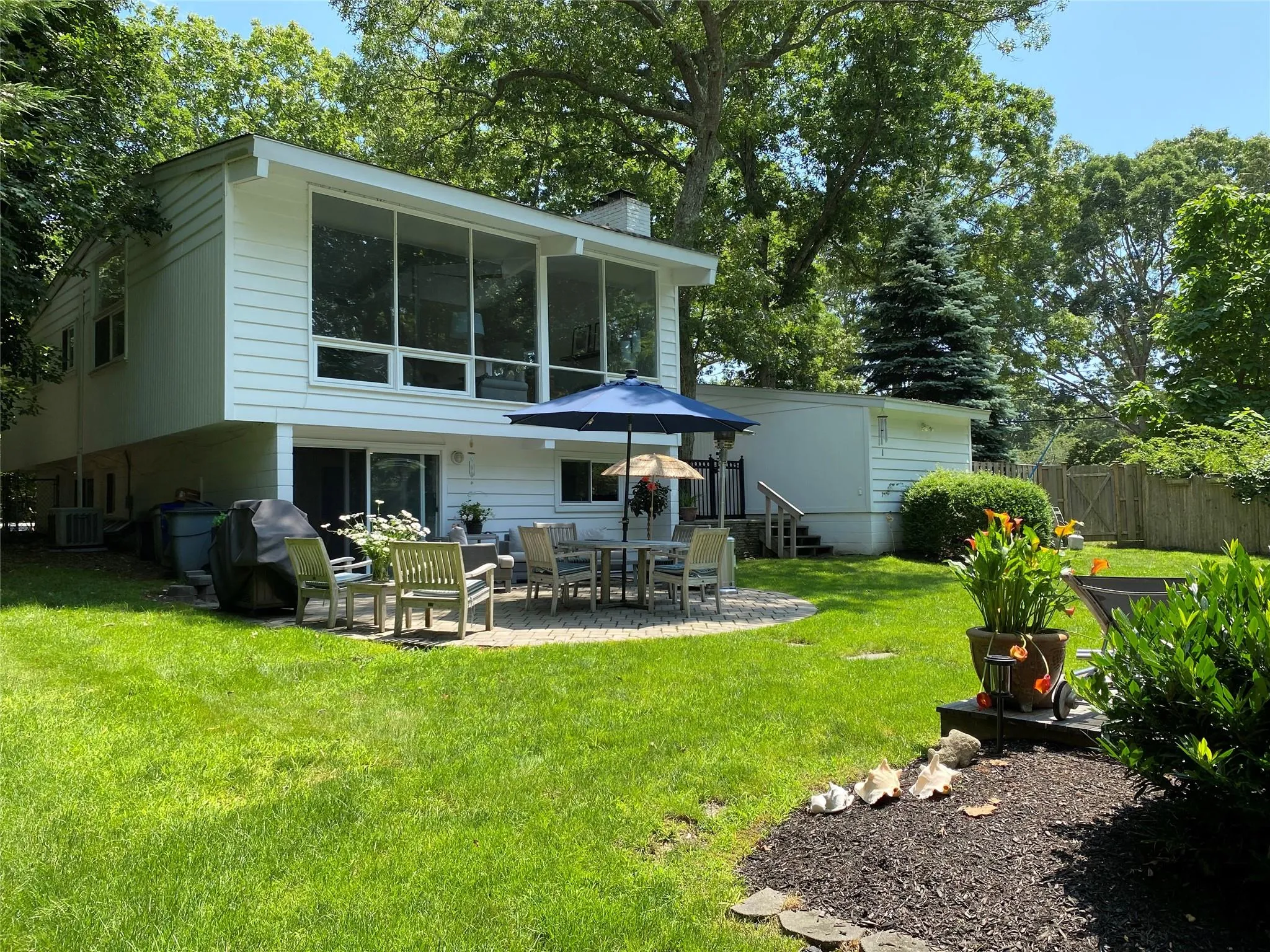 Rear view of house featuring a yard, central AC unit, a patio area, and a sunroom Rear view of house featuring a yard, central AC unit, a patio area, and a sunroom
