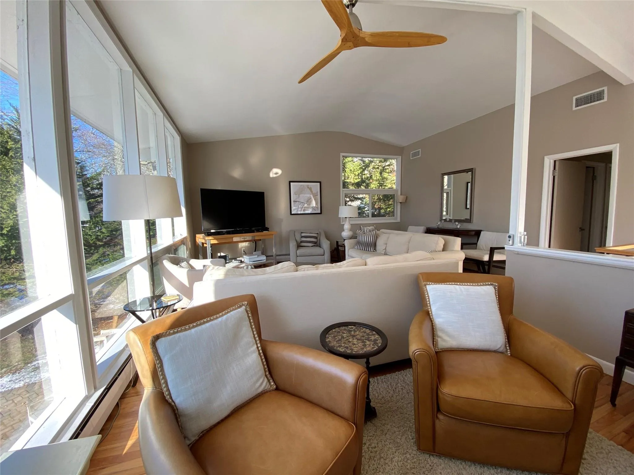 Living room featuring lofted ceiling, light hardwood / wood-style flooring, floor to ceiling windows, and ceiling fan Living room featuring lofted ceiling, light hardwood / wood-style flooring, floor to ceiling windows, and ceiling fan
