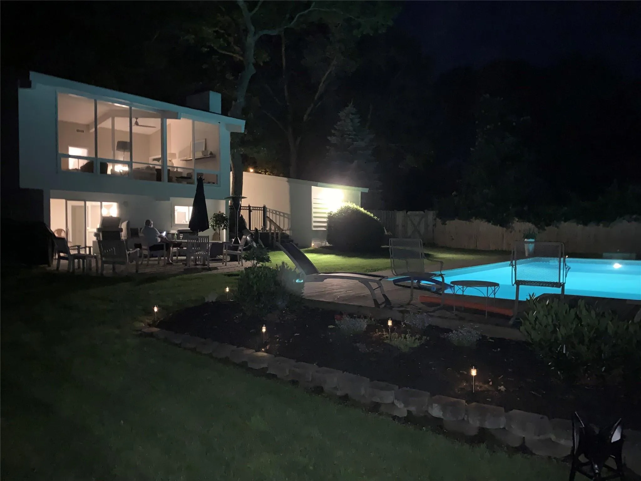 Pool at twilight featuring a yard and a patio area Pool at twilight featuring a yard and a patio area