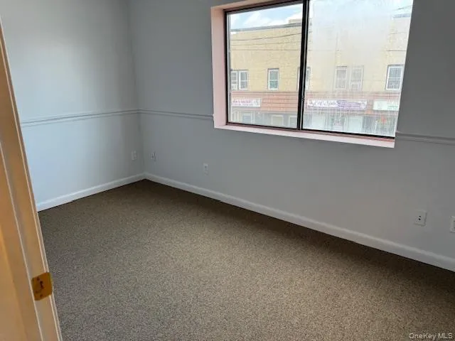 Carpeted spare room featuring baseboards Carpeted spare room featuring baseboards