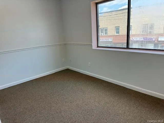 Empty room with dark carpet and baseboards Empty room with dark carpet and baseboards
