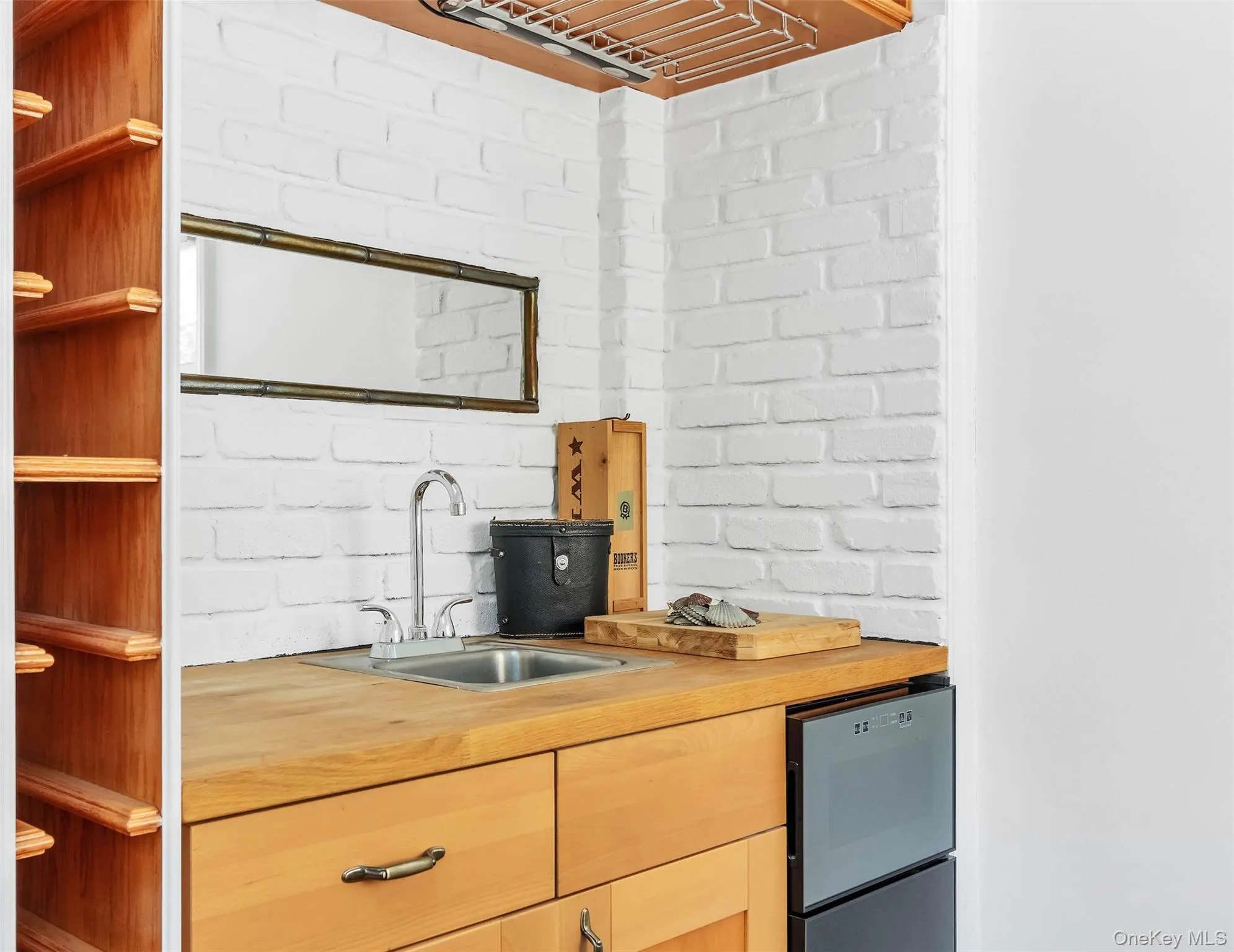 Kitchen with sink, wooden counters, and brick wall Kitchen with sink, wooden counters, and brick wall