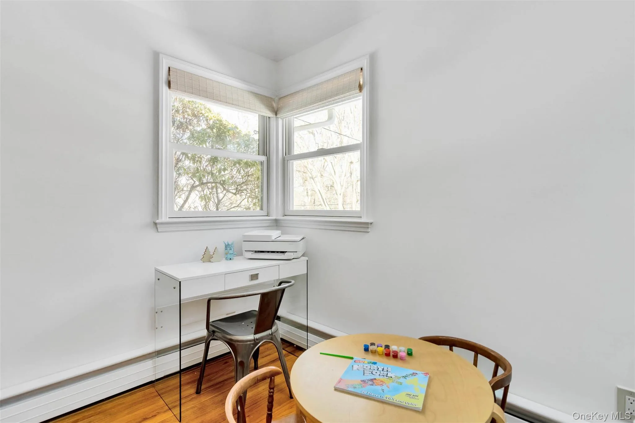 Home office featuring hardwood / wood-style floors and baseboard heating Home office featuring hardwood / wood-style floors and baseboard heating