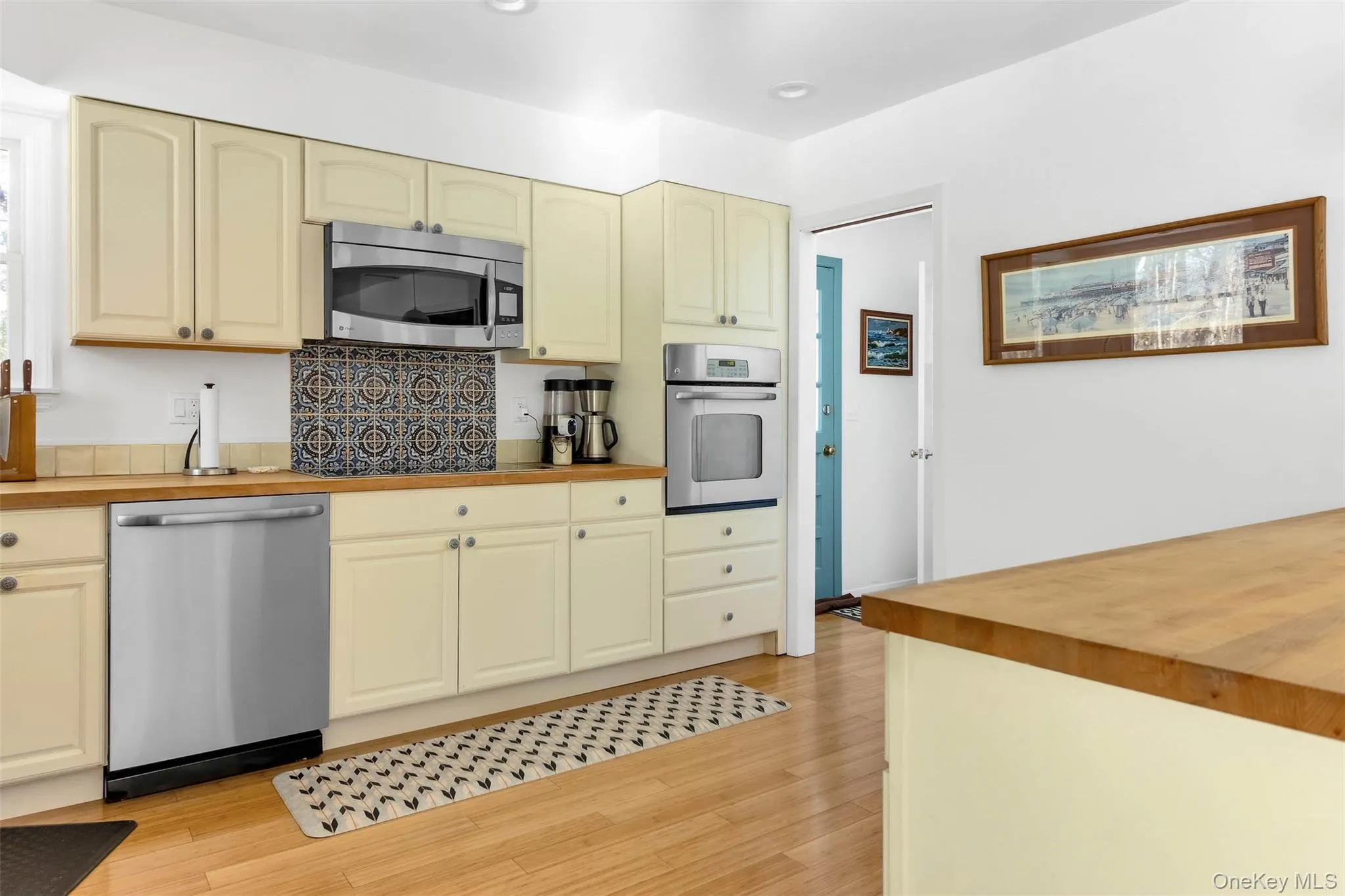 Kitchen with stainless steel appliances, butcher block countertops, and light wood-type flooring Kitchen with stainless steel appliances, butcher block countertops, and light wood-type flooring