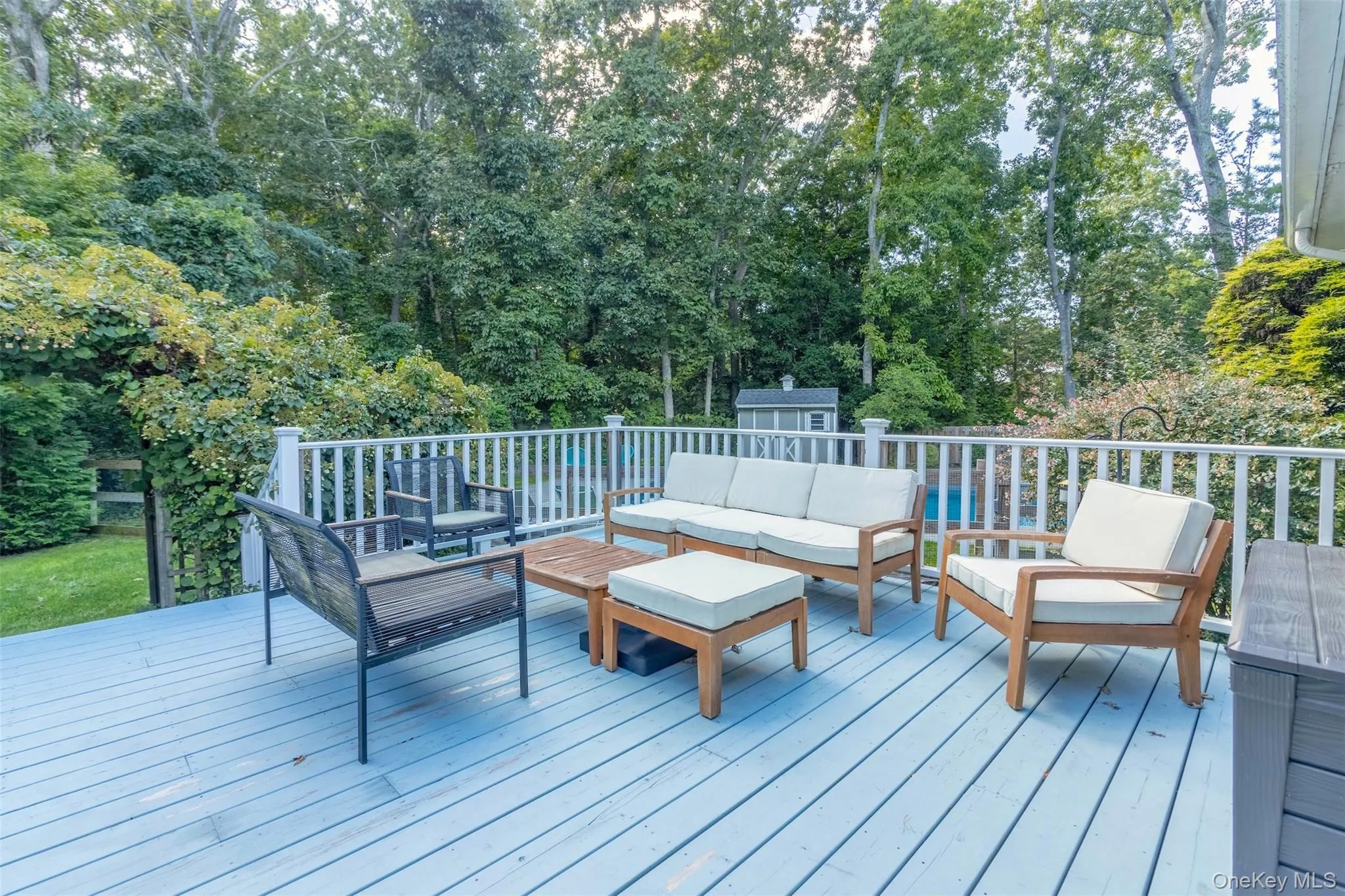 Wooden terrace with an outdoor hangout area and view of wooded area Wooden terrace with an outdoor hangout area and view of wooded area