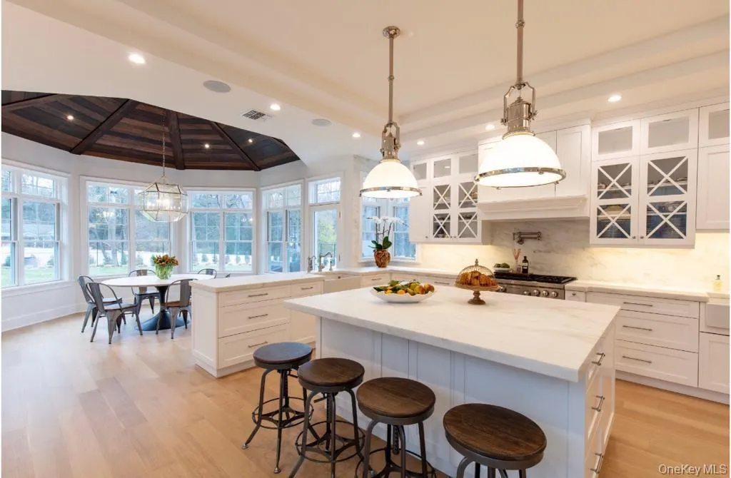 Rendering of kitchen with visible vents, light wood-type flooring, a kitchen island, beam ceiling, and a peninsula Rendering of kitchen with visible vents, light wood-type flooring, a kitchen island, beam ceiling, and a peninsula