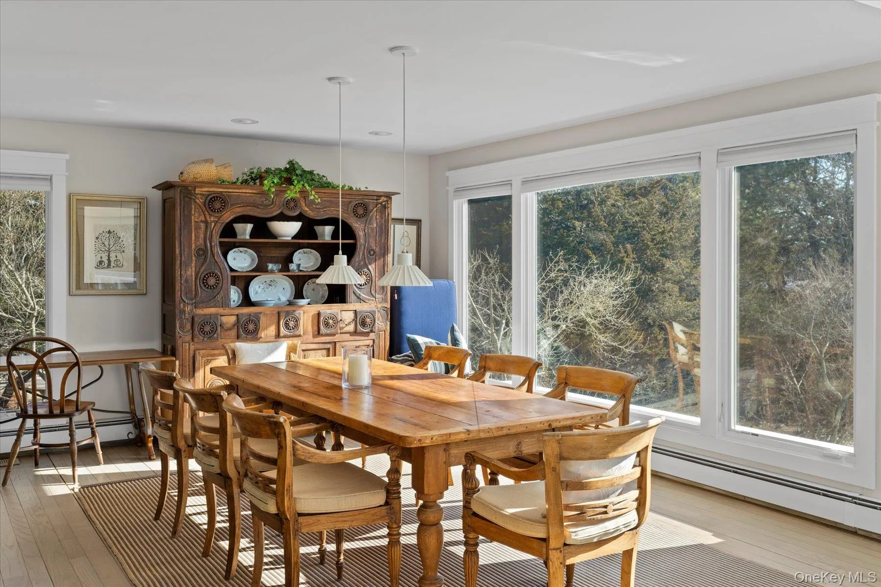 Dining room with light wood-type flooring and a window wall offering views Dining room with light wood-type flooring and a window wall offering views