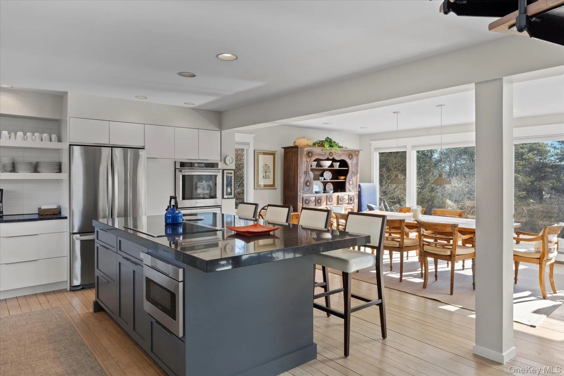 Kitchen featuring a center island, light hardwood / wood-style floors, white cabinets, stainless steel appliances, and a breakfast bar area Kitchen featuring a center island, light hardwood / wood-style floors, white cabinets, stainless steel appliances, and a breakfast bar area
