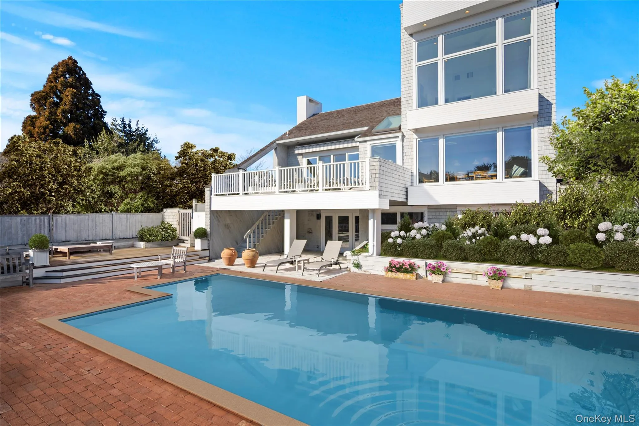 Back of house with a fenced in pool, a patio, and a balcony Back of house with a fenced in pool, a patio, and a balcony