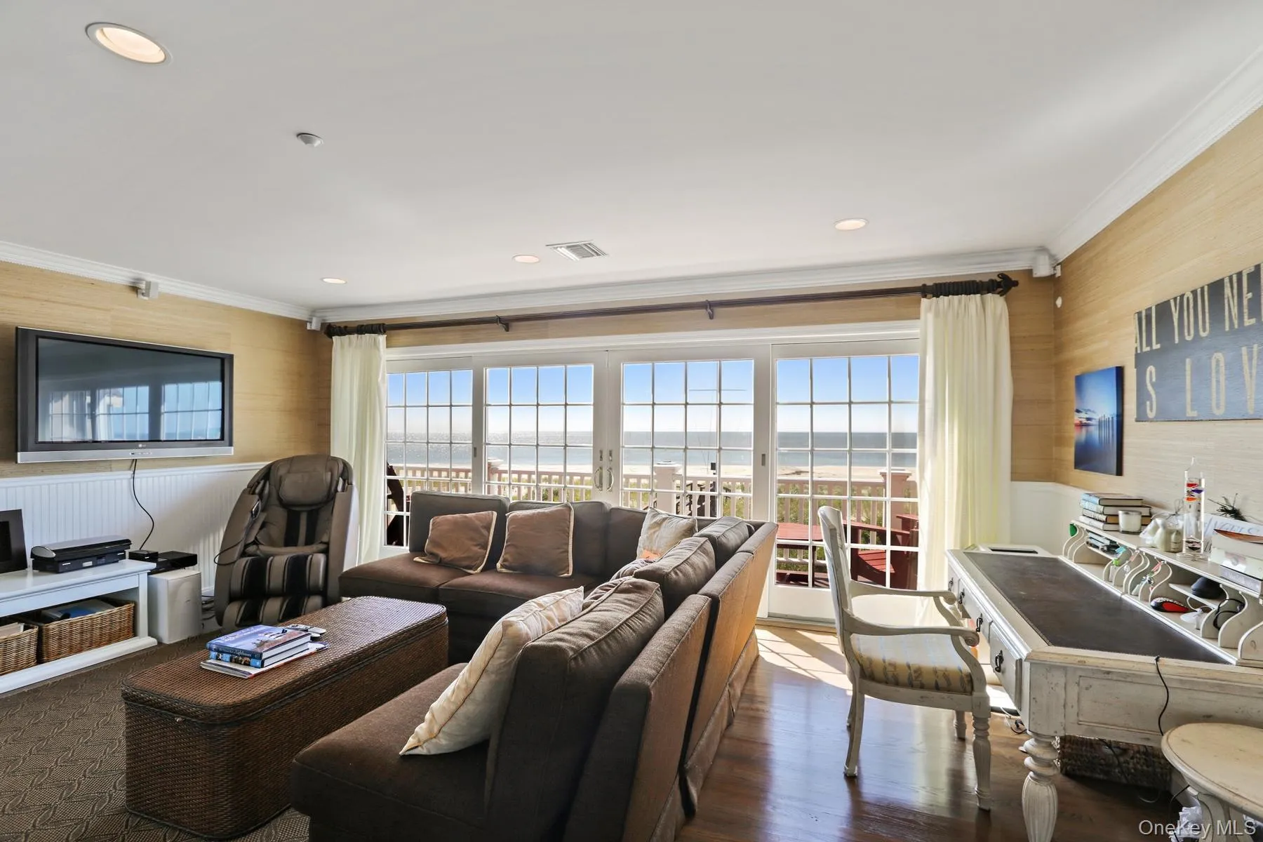 Living room with crown molding, a water view, plenty of natural light, and dark hardwood / wood-style flooring Living room with crown molding, a water view, plenty of natural light, and dark hardwood / wood-style flooring