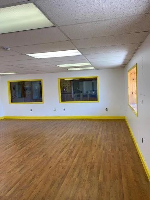 Inside Space with hardwood / wood-style floors and a drop ceiling Inside Space with hardwood / wood-style floors and a drop ceiling
