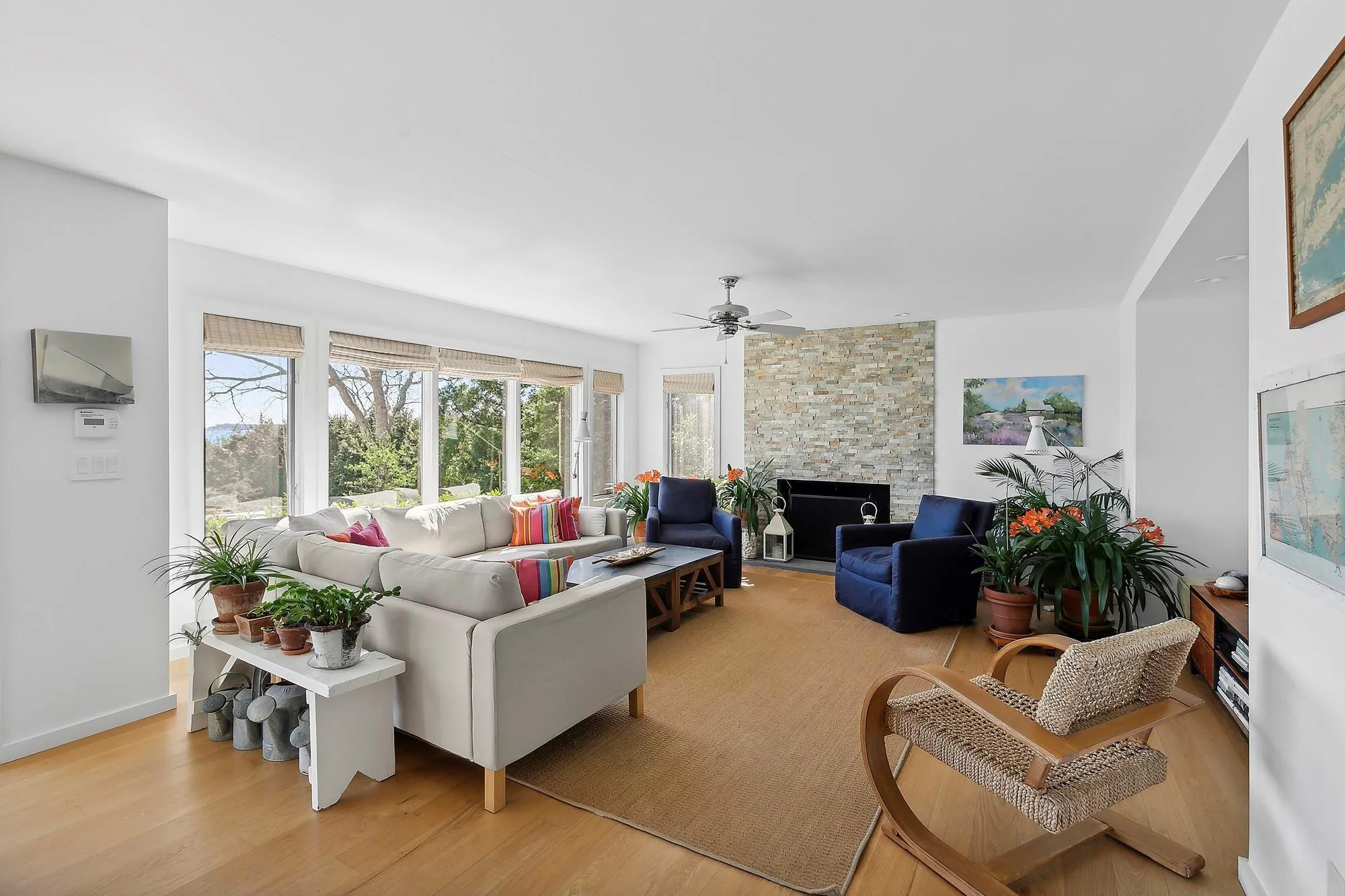 Living room with a fireplace, light hardwood / wood-style flooring, and ceiling fan Living room with a fireplace, light hardwood / wood-style flooring, and ceiling fan