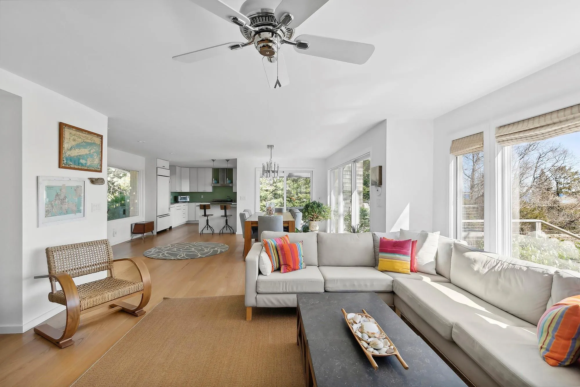 Living room featuring ceiling fan with notable chandelier and hardwood / wood-style flooring Living room featuring ceiling fan with notable chandelier and hardwood / wood-style flooring