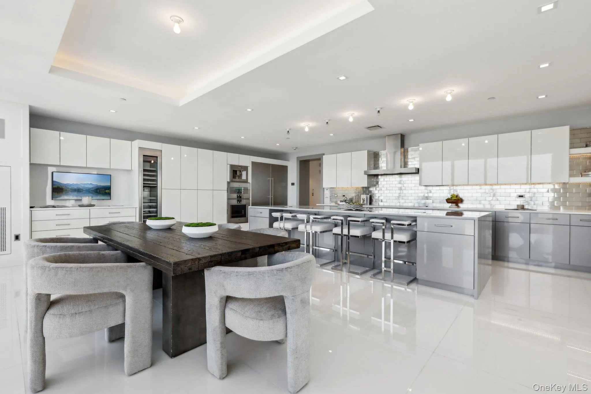 Dining room with light tile patterned floors, a raised ceiling, and recessed lighting Dining room with light tile patterned floors, a raised ceiling, and recessed lighting