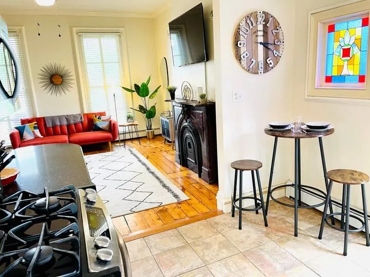 Living room with light hardwood / wood-style floors, ornamental molding, and a baseboard radiator Living room with light hardwood / wood-style floors, ornamental molding, and a baseboard radiator