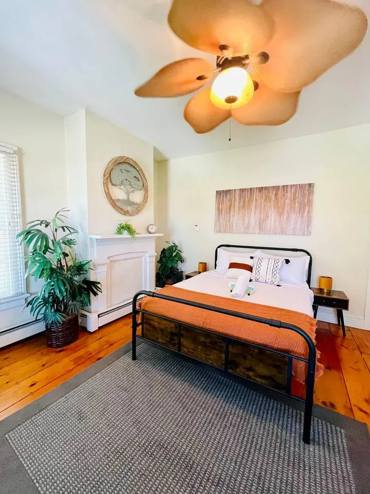 Bedroom 1 featuring hardwood / wood-style floors, a baseboard radiator, and ceiling fan Bedroom 1 featuring hardwood / wood-style floors, a baseboard radiator, and ceiling fan