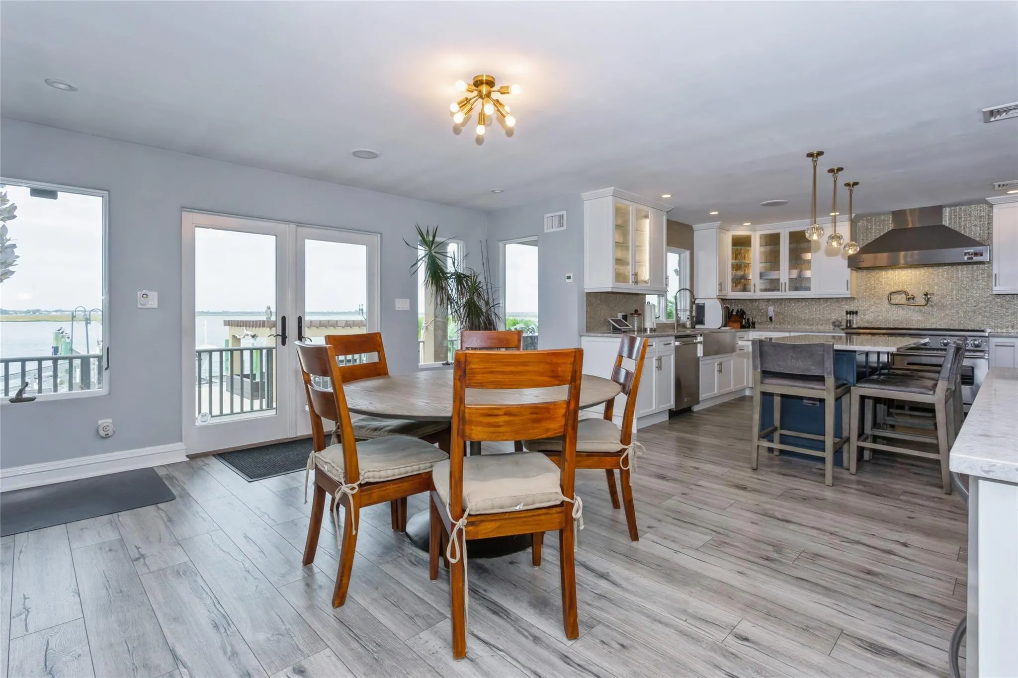 Dining space featuring french doors, a wealth of natural light, and light hardwood / wood-style floors Dining space featuring french doors, a wealth of natural light, and light hardwood / wood-style floors