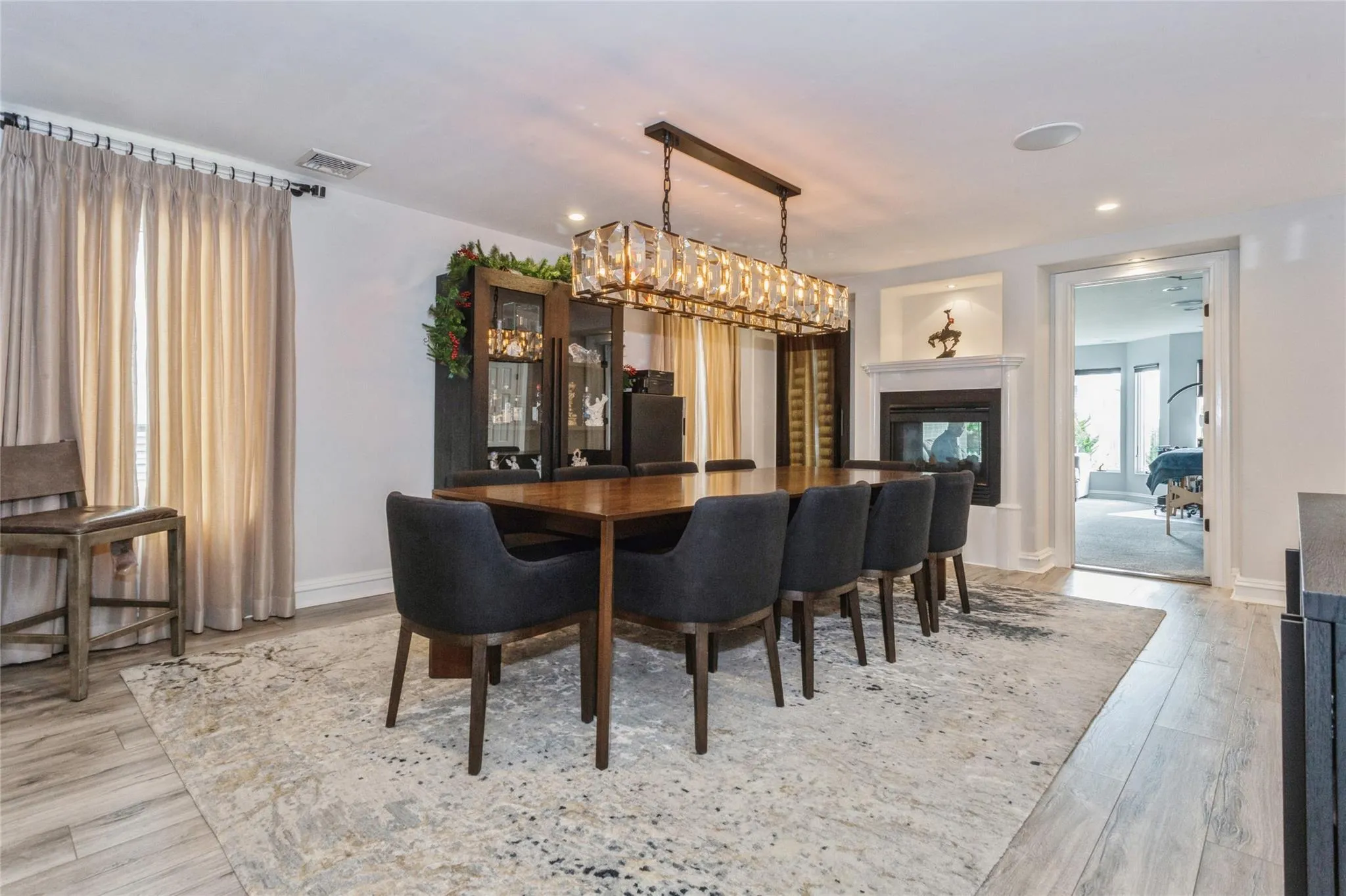 Dining area with a multi sided fireplace and light hardwood / wood-style flooring Dining area with a multi sided fireplace and light hardwood / wood-style flooring