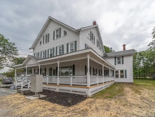 View of front facade featuring a porch and a chimney View of front facade featuring a porch and a chimney