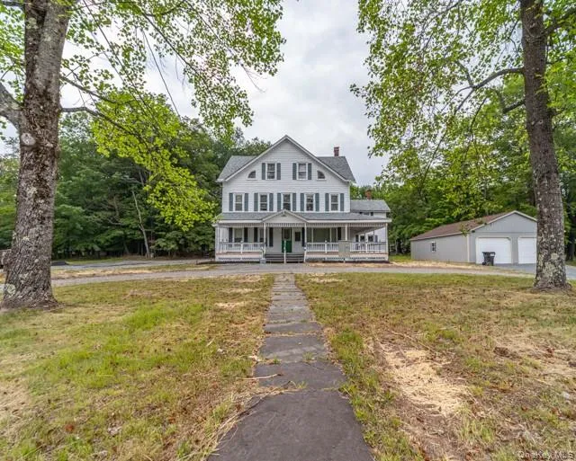 View of front of house with an outbuilding, covered porch, and a front yard View of front of house with an outbuilding, covered porch, and a front yard