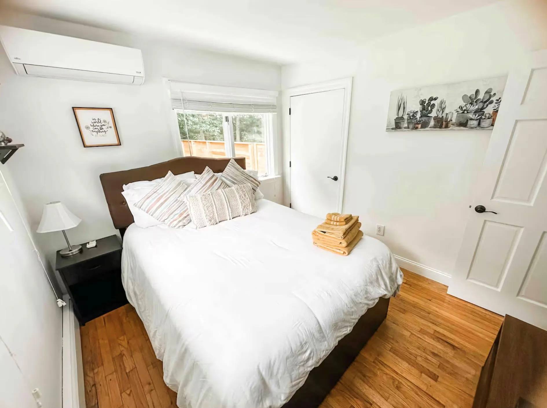 Bedroom with baseboards, wood finished floors, and a wall mounted AC Bedroom with baseboards, wood finished floors, and a wall mounted AC