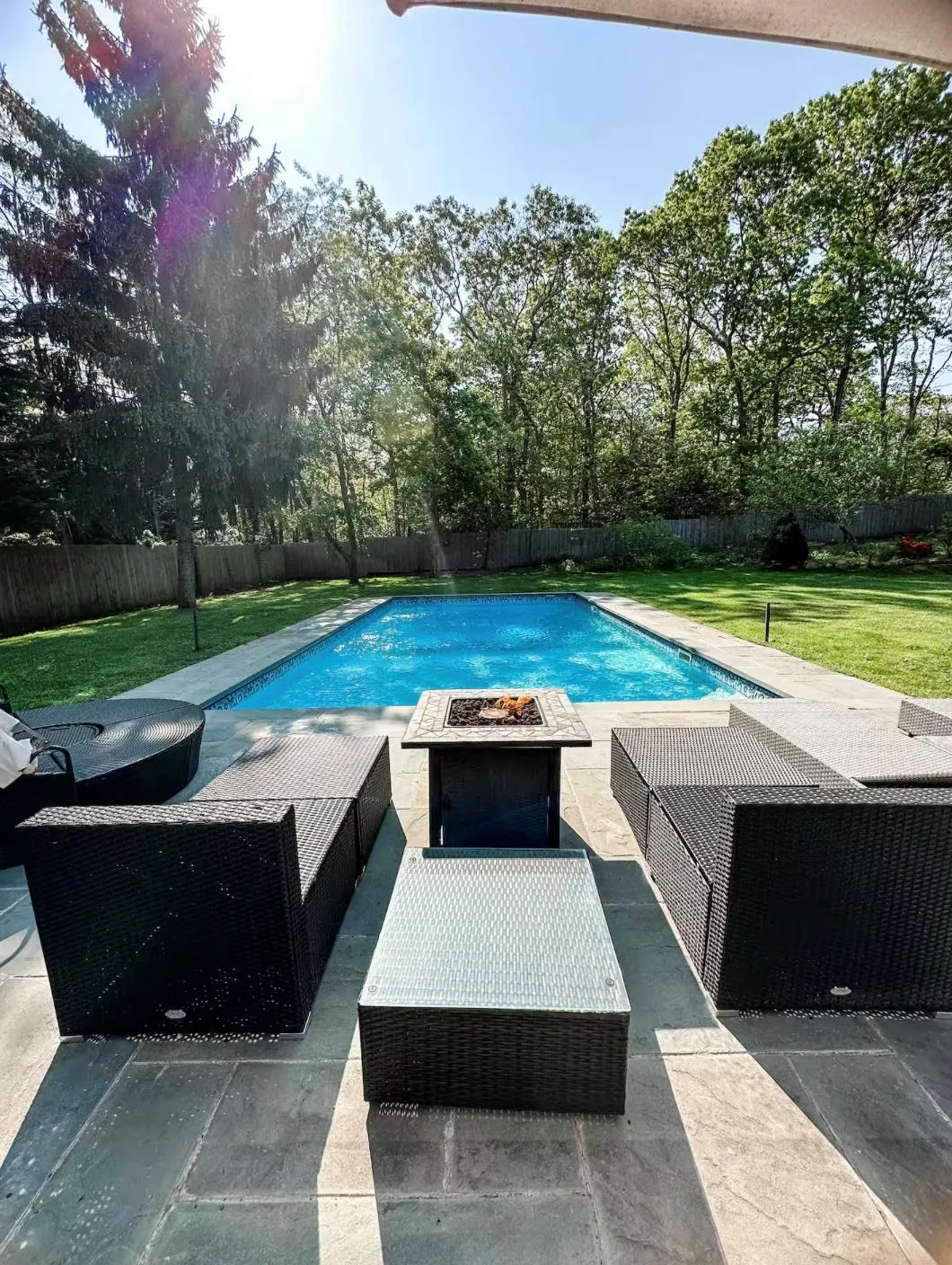 View of pool with a fenced backyard, a lawn, and a fire pit View of pool with a fenced backyard, a lawn, and a fire pit