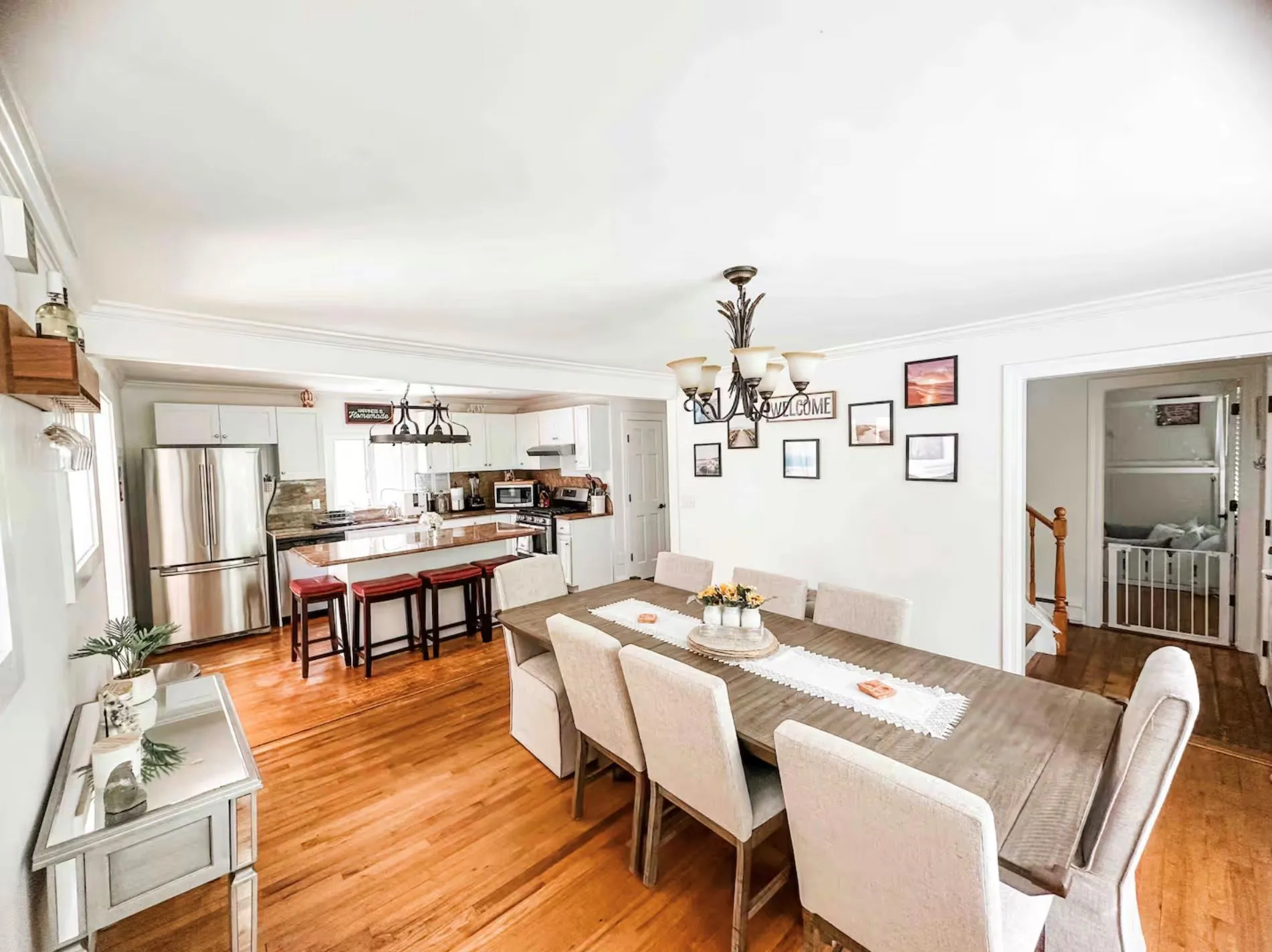 Dining area featuring crown molding, light wood-type flooring, a notable chandelier, and stairs Dining area featuring crown molding, light wood-type flooring, a notable chandelier, and stairs