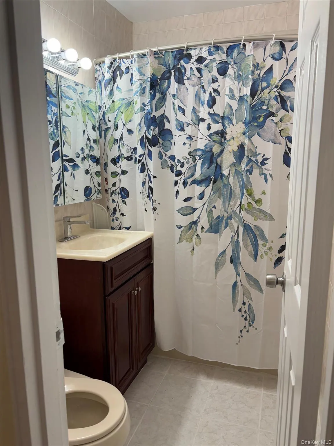 Bathroom with tile patterned flooring, vanity, and toilet Bathroom with tile patterned flooring, vanity, and toilet