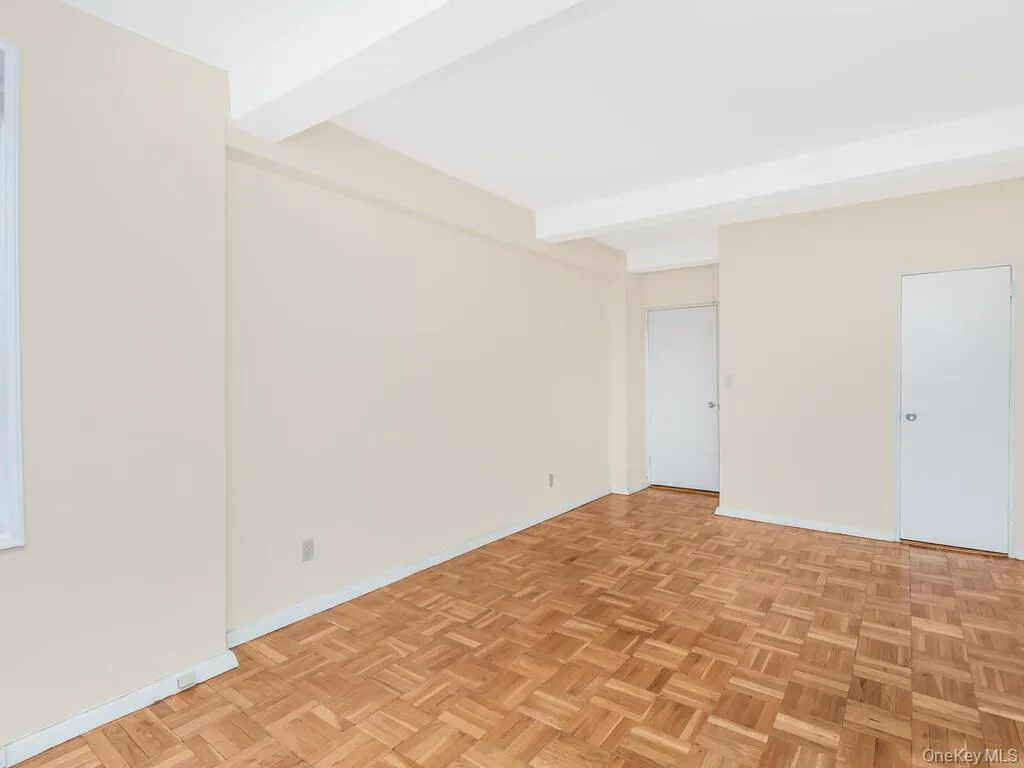 Unfurnished room featuring beamed ceiling and baseboards Unfurnished room featuring beamed ceiling and baseboards